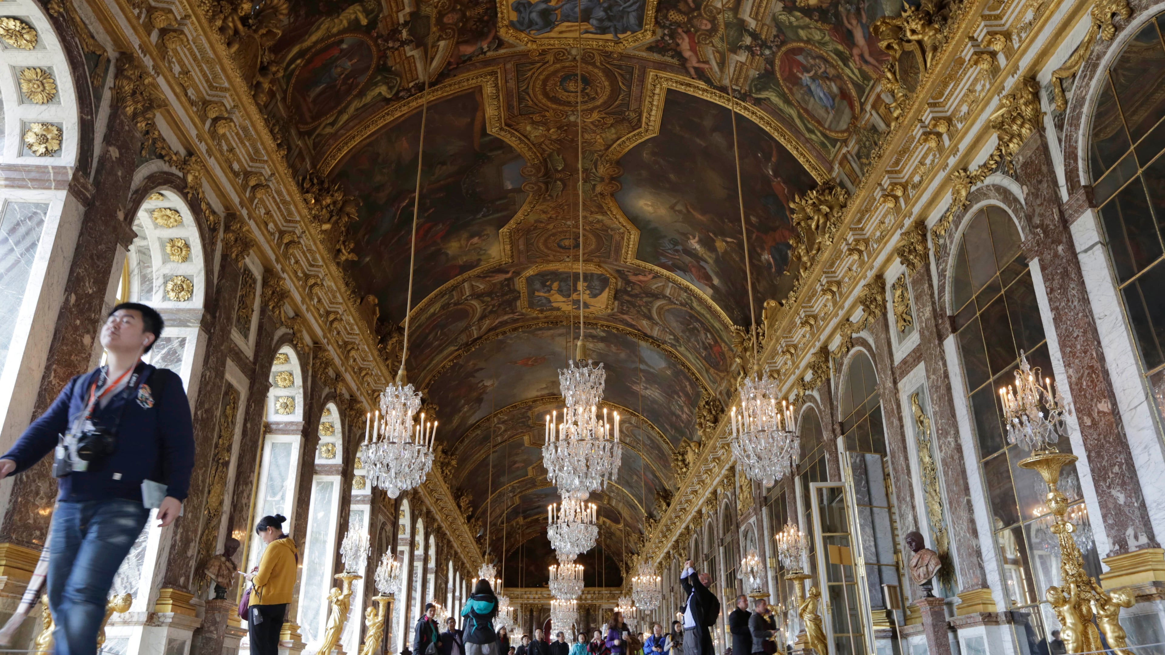 FILE - Visitors walk inside the Hall of Mirrors in the Versailles castle, on Nov. 17, 2015 in Versailles, west of Paris. (AP Photo/Amr Nabil, File)