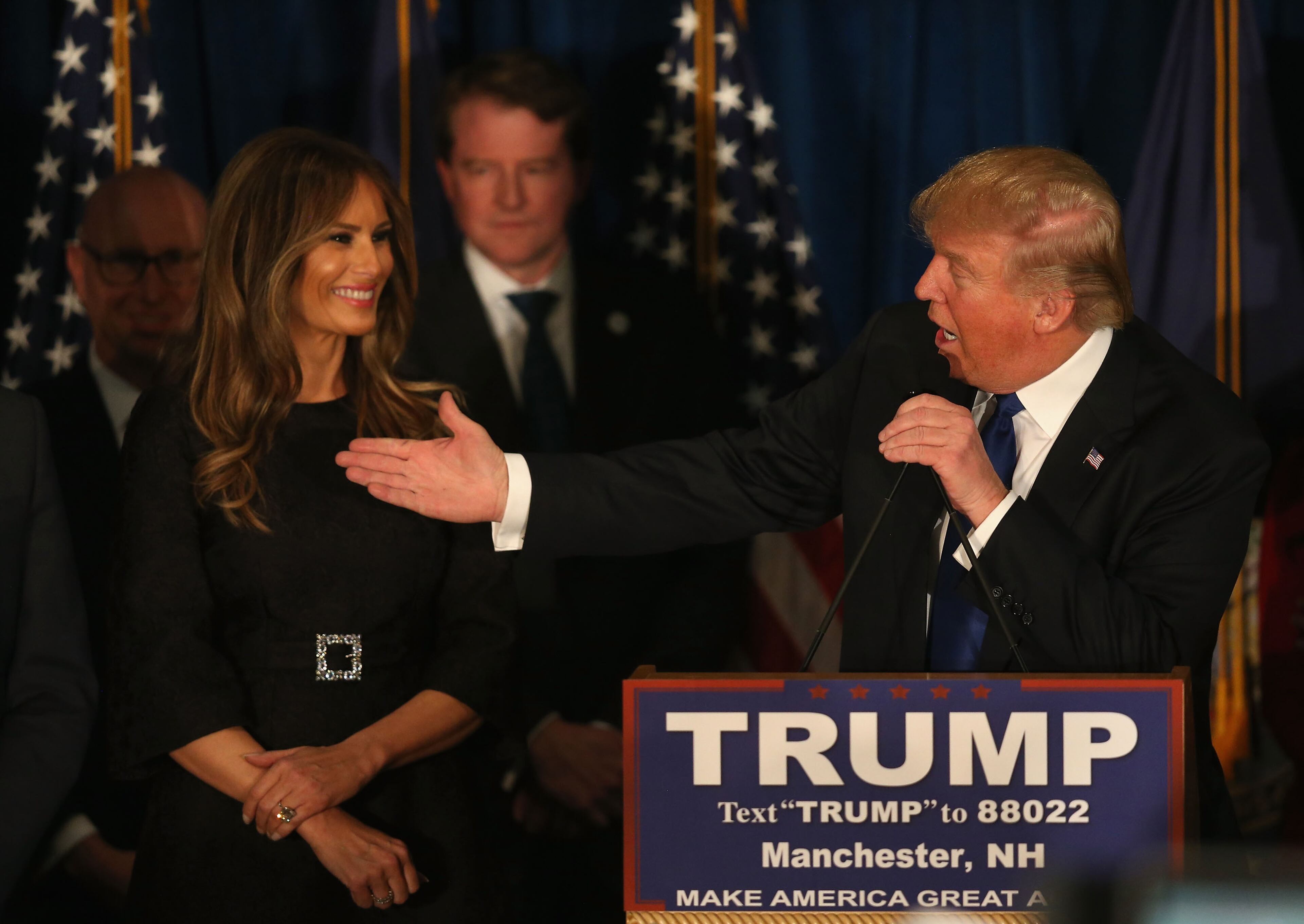 Republican presidential candidate Donald Trump speaks as his wife Melania Trump looks on after Primary day at his election night watch party at the Executive Court Banquet facility on February 9, 2016 in Manchester, New Hampshire. (Photo by Joe Raedle/Getty Images)