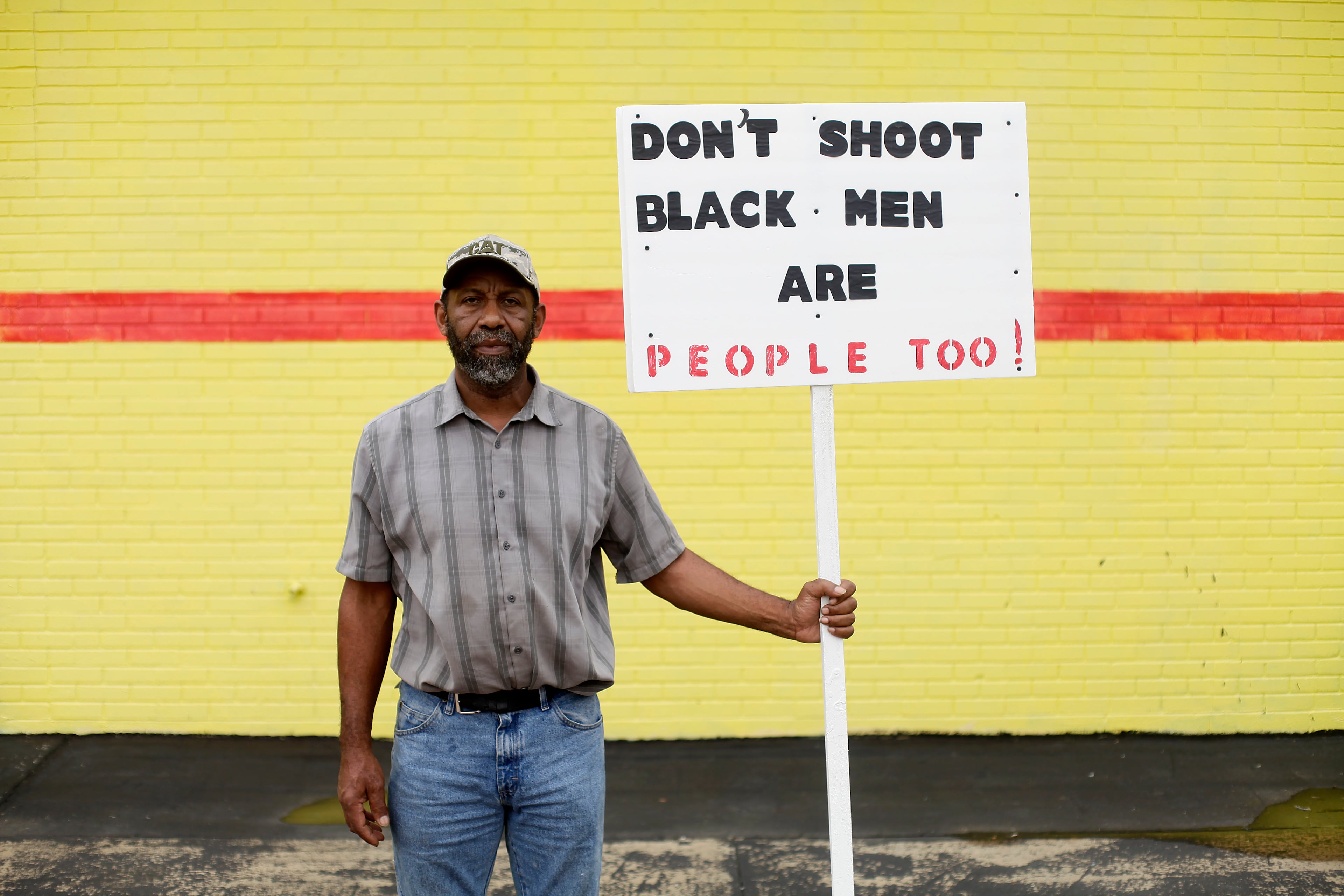 John Morgan, a demonstrator protesting Michael Brown's murder, poses for a portrait with his sign August 17, 2014 in Ferguson, Missouri.Tensions still run high in the Ferguson community after 18 -year-old Michael Brown was killed by a Ferguson Police Officer August 9 on Canfield Drive. (Photo by Joshua Lott/Getty Images)
