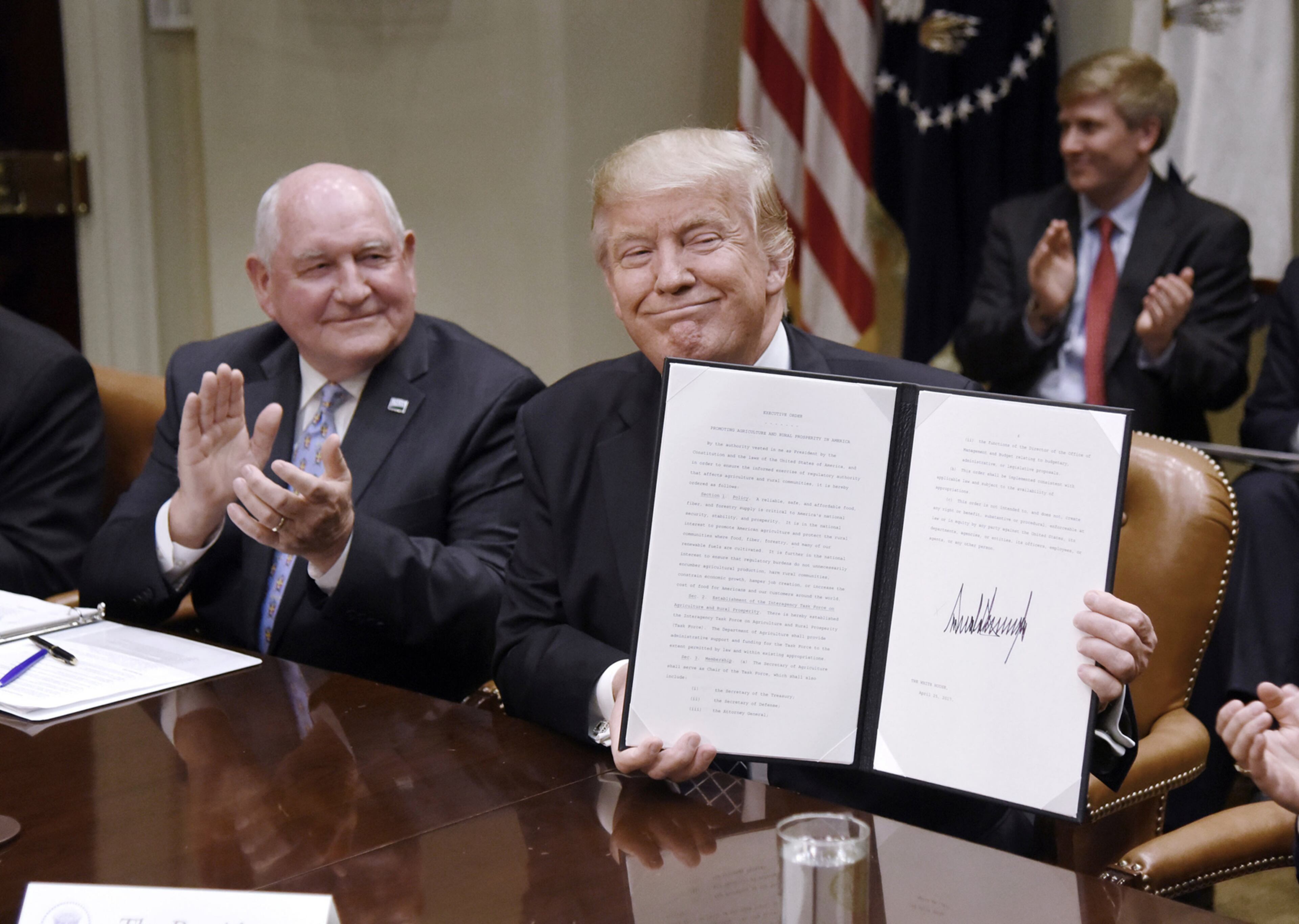 U.S. President Donald Trump signs the Executive Order Promoting Agriculture and Rural Prosperity in America as agriculture secretary Sonny Perdue looks on during a roundtable with farmers on Tuesday, April 25, 2017 in the Roosevelt Room of the White House in Washington, D.C. (Olivier Douliery/Abaca Press/TNS)