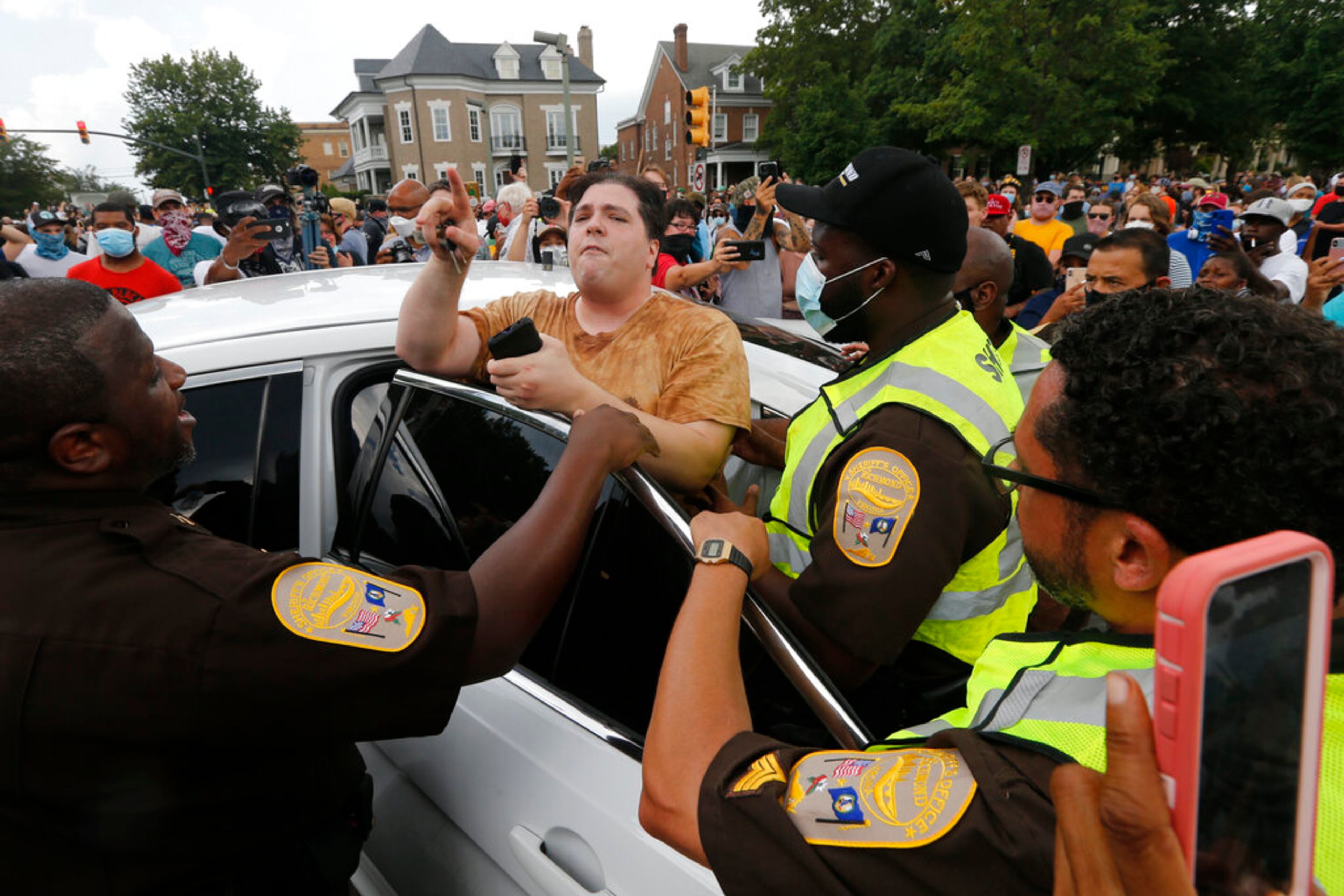 A protester in favor of the monument speaks to authorities and is removed from the area as work crews remove the statue of confederate general Stonewall Jackson, Wednesday, July 1, 2020, in Richmond, Va. Richmond Mayor Levar Stoney has ordered the immediate removal of all Confederate statues in the city, saying he was using his emergency powers to speed up the healing process for the former capital of the Confederacy amid weeks of protests over police brutality and racial injustice. (AP Photo/Steve Helber)