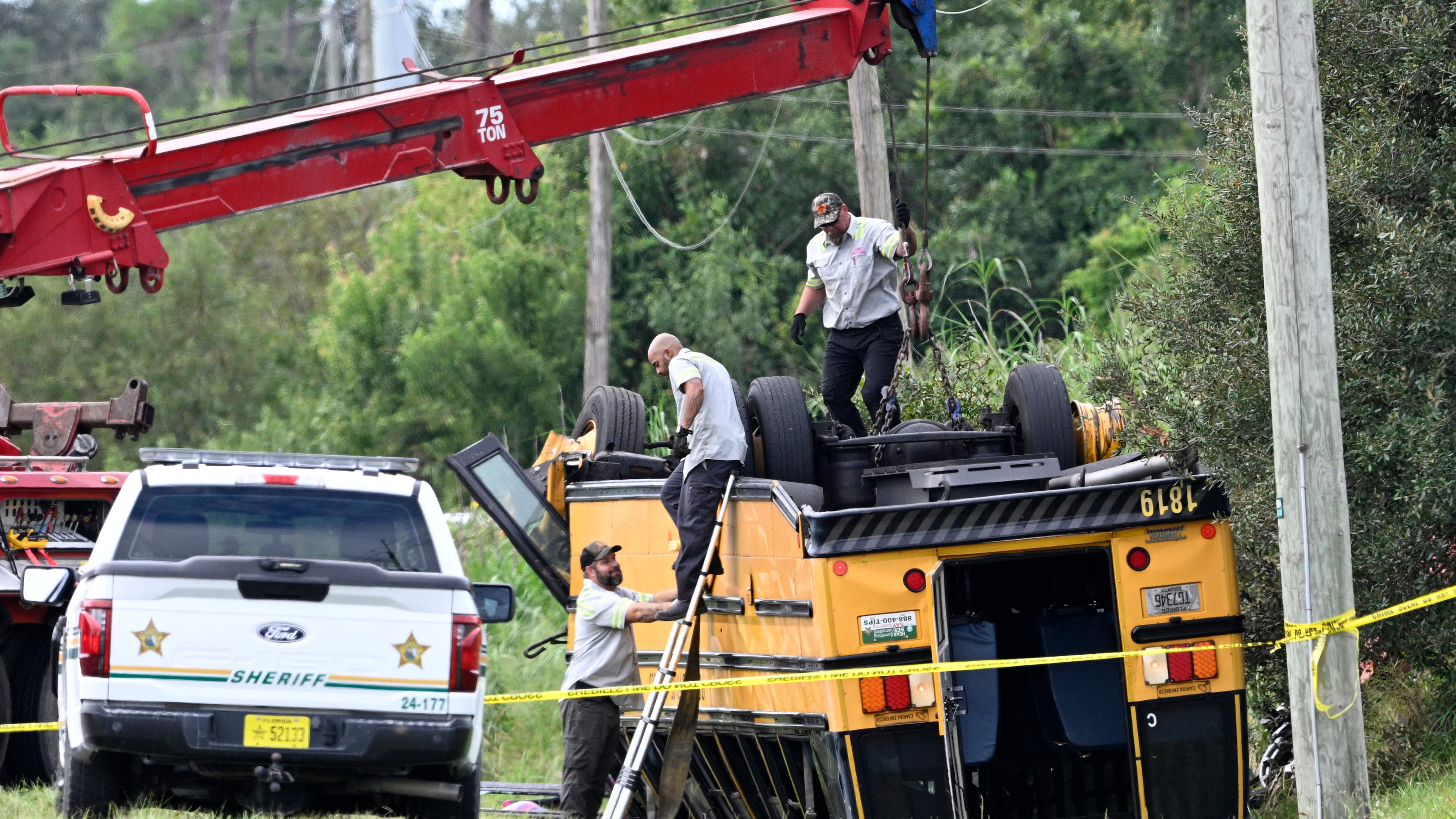 A vehicle recovery crew work to right an overturned school bus after a fatal collision, Monday, Oct. 5, 2026, in Winter Haven, Fla. (AP Photo/Phelan M. Ebenhack)