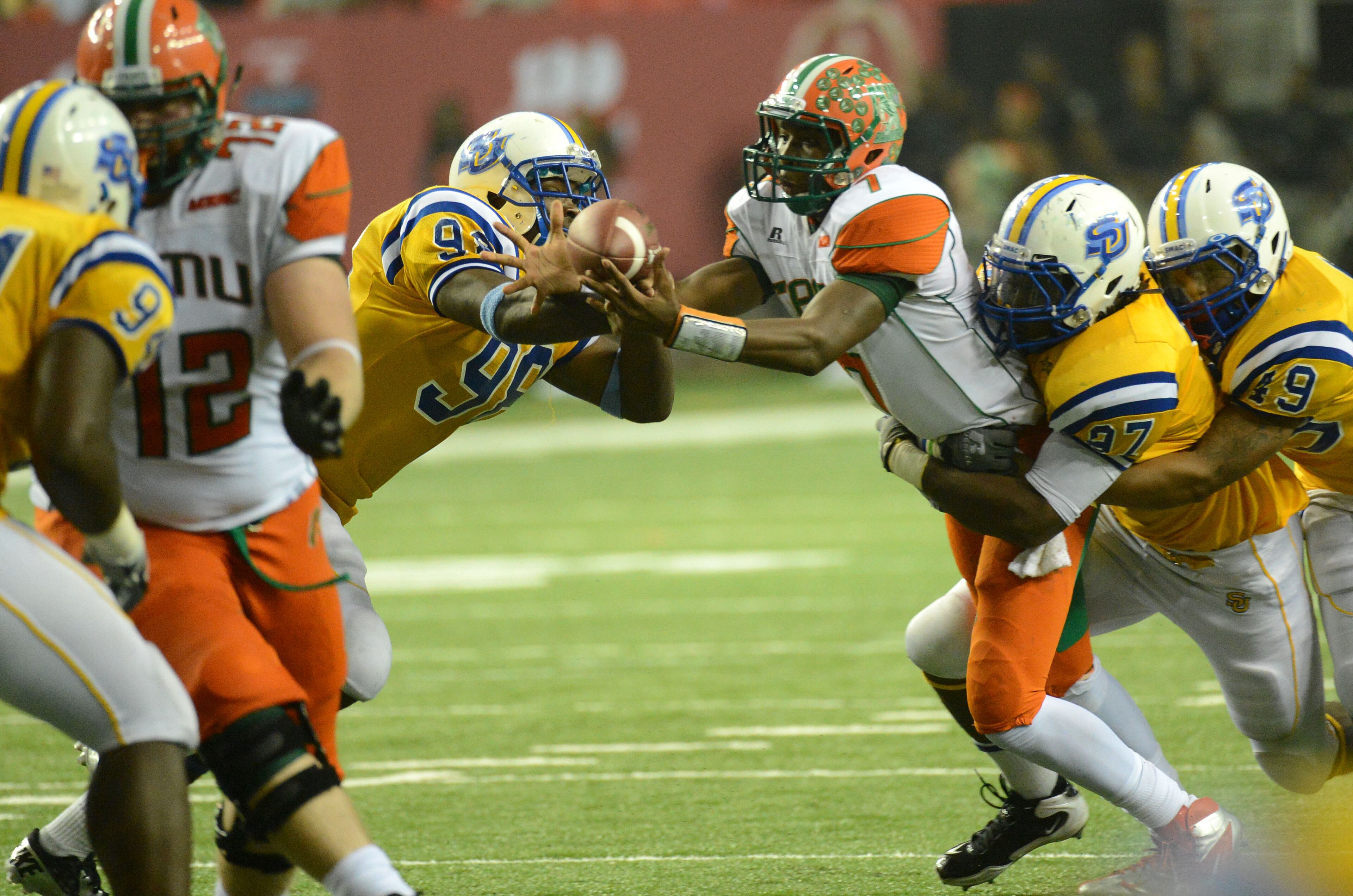 Florida A&M quarterback Damien Fleming (7) and Southern linebacker Daniel Brown (98) fight for a loose ball as Southern defensive tackle Gerard Levier (97) and Southern linebacker Anthony Balancier (49) hold him in the second half during the 2012 Bank of America Atlanta Football Classic at the Georgia Dome on Saturday, September 29, 2012. Southern won 21-14 over the Florida A&M.