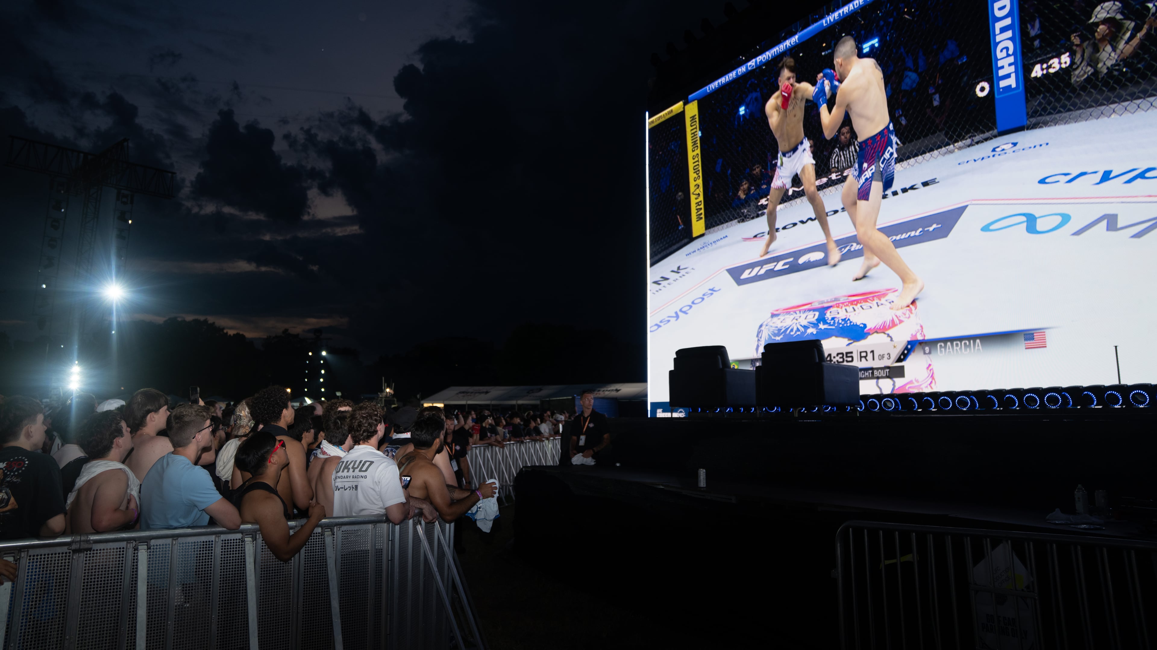 Attendees watch the first match at the UFC Fan Fest on the White House Ellipse ahead of the fights on the South Lawn, Sunday, June 14, 2026, in Washington. (AP Photo/Allison Robbert)