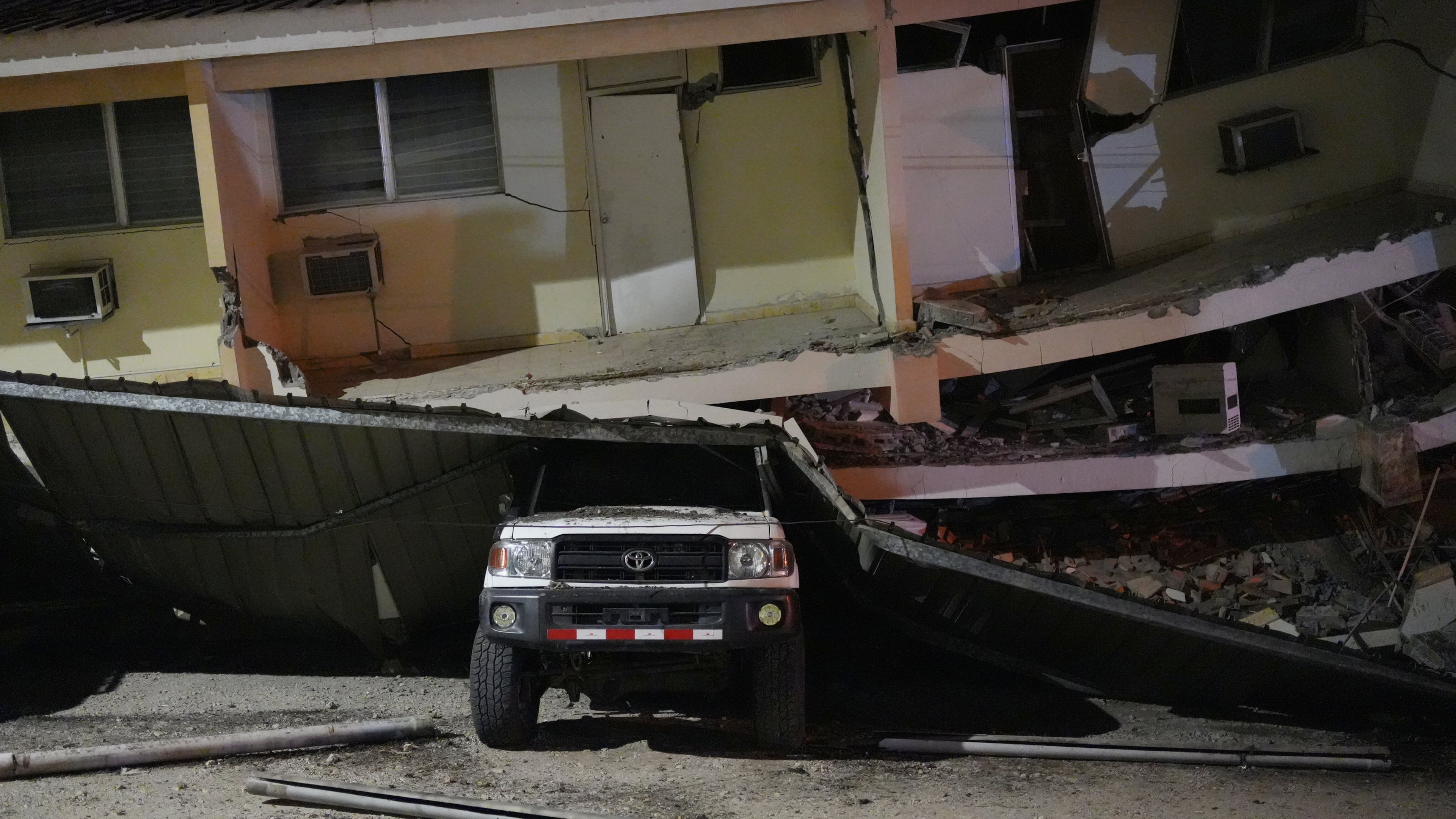 A vehicle lies crushed beneath a collapsed building after an earthquake struck Penonome, Panama, Friday, Oct. 9, 2026. (AP Photo/Aris Mariota)