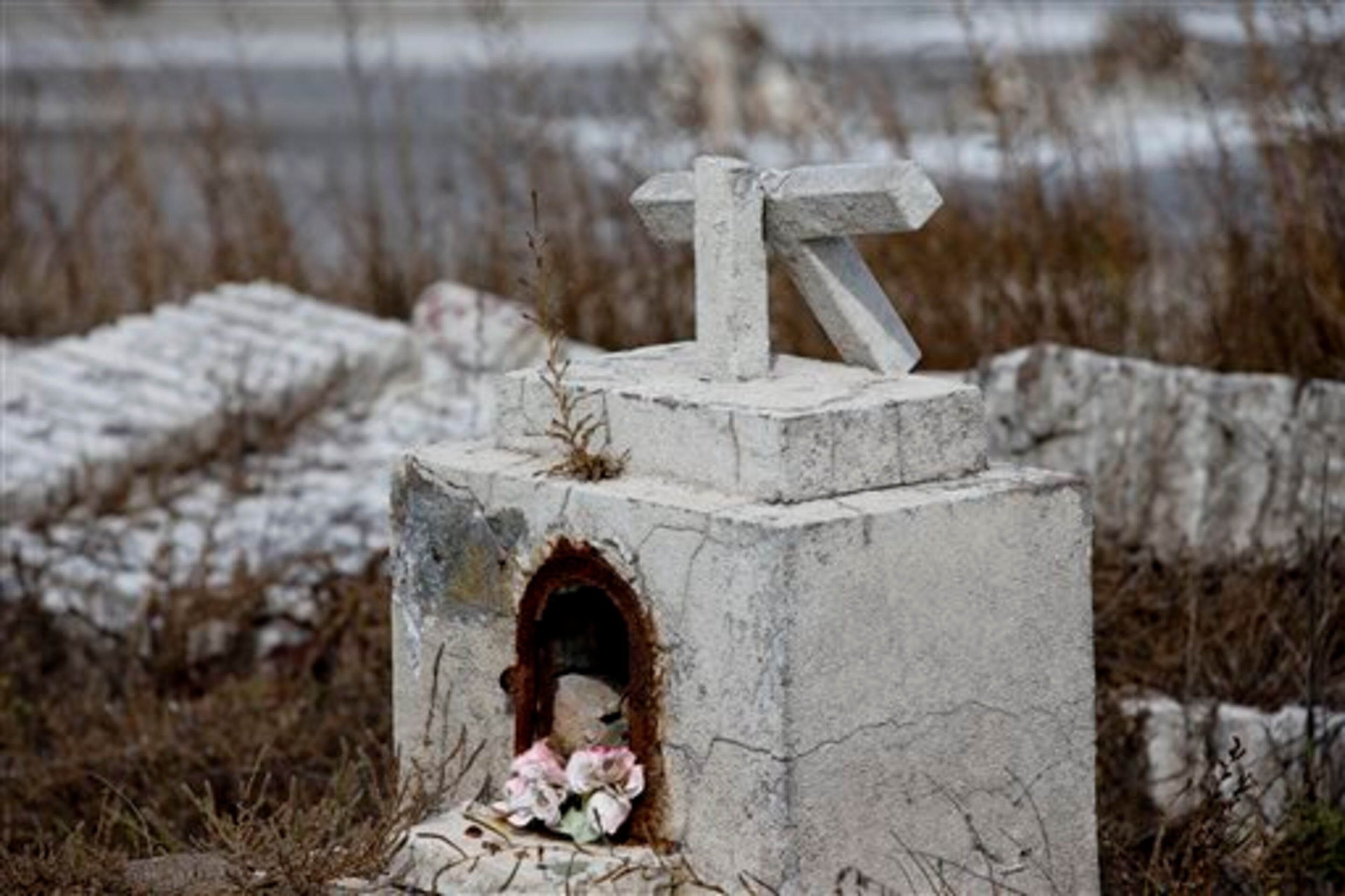 In this May 7, 2013 photo, a cross lies broken on a tomb in the abandoned town of Epecuen, Argentina. This town was once home to 1,500 residents, but they were forced to leave in 1985 when heavy rains made the nearby lake overrun its banks and submerged the town beneath almost 30 feet of water. The town was never rebuilt as the water started to recede. (AP Photo/Natacha Pisarenko)