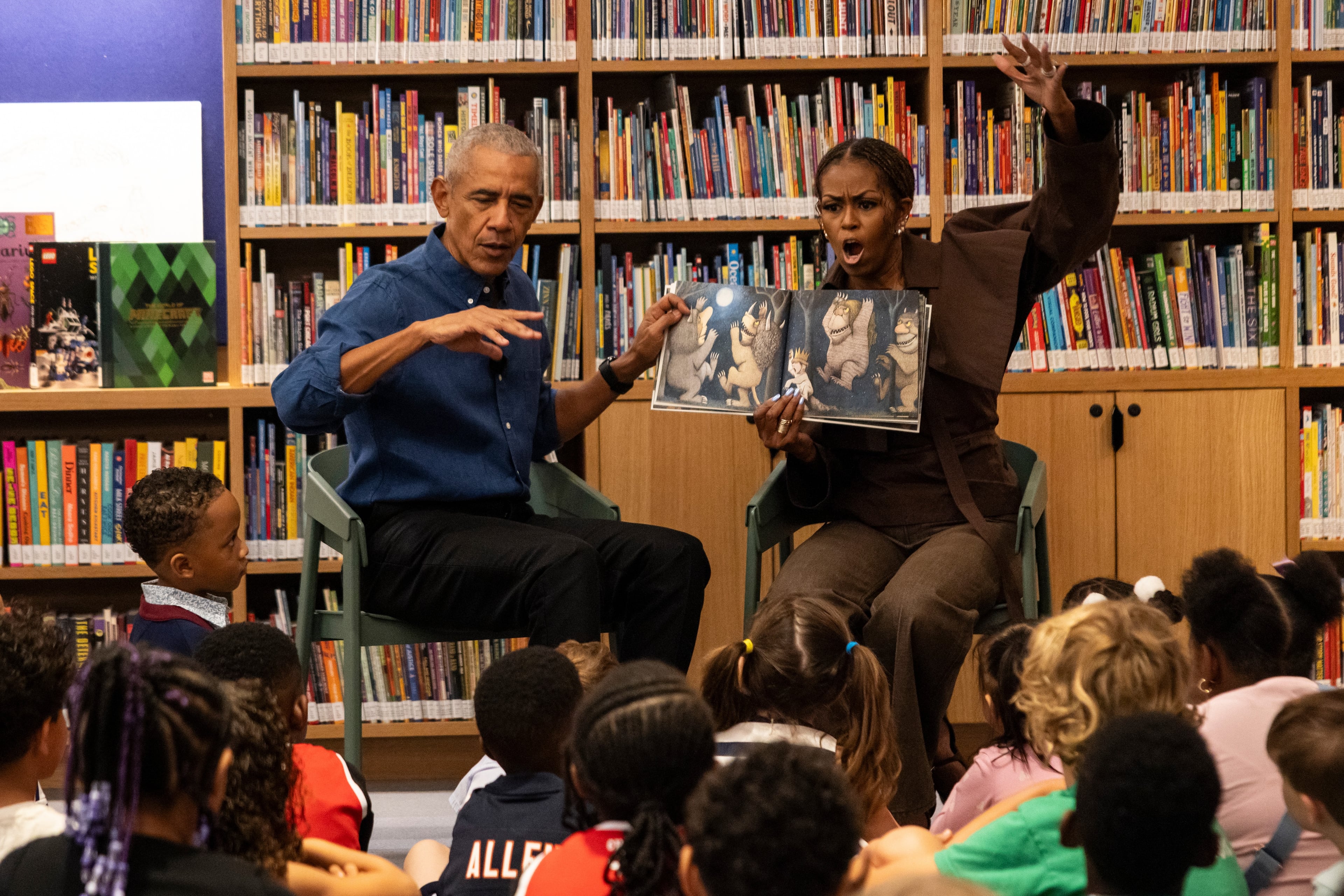 Former President Barack Obama and former first lady Michelle Obama read “Where the Wild Things Are” to children inside the Obama Presidential Center’s Chicago Public Library branch on Friday, June 19, 2026. (Ashlee Rezin/AP Pool)