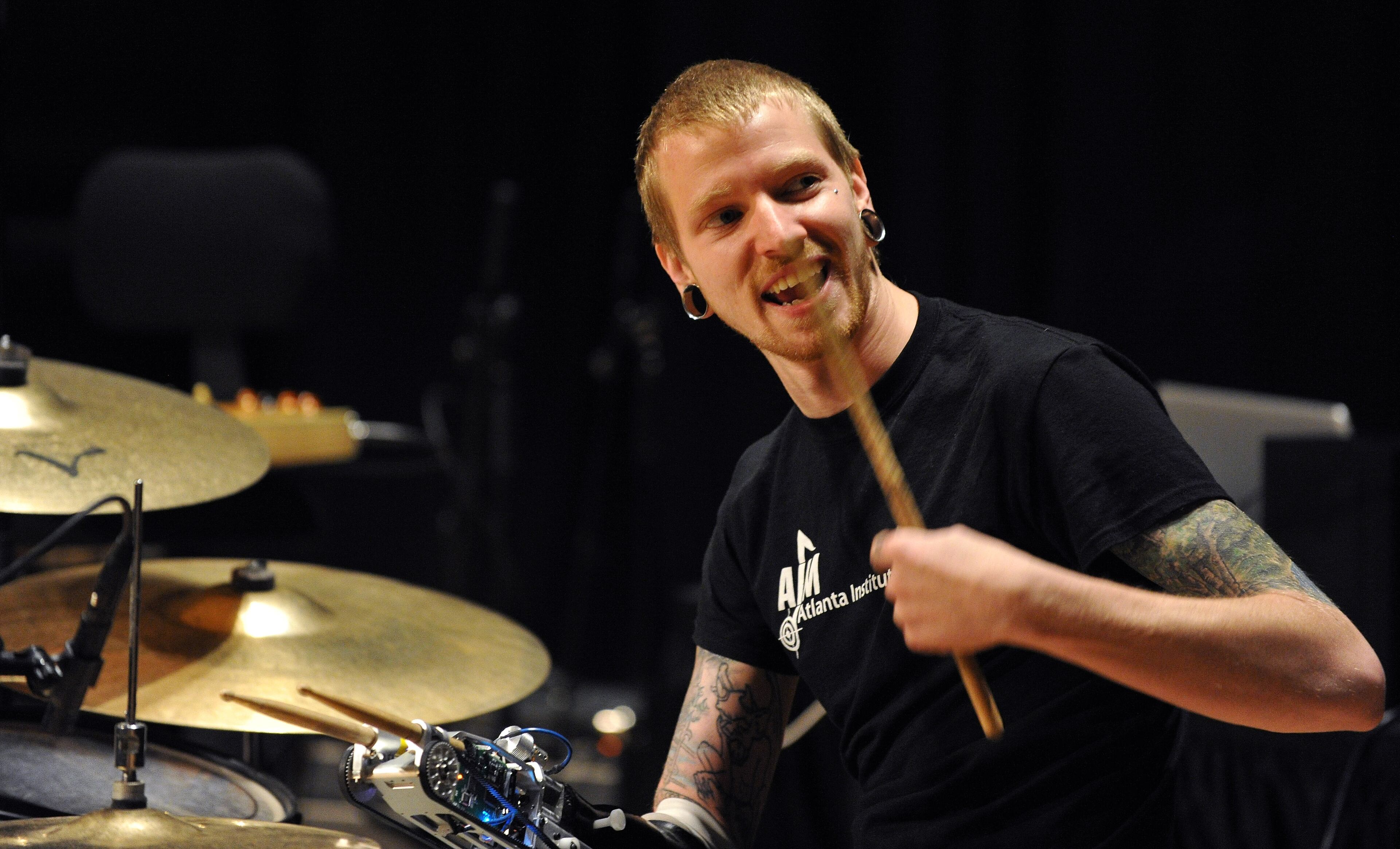 Musician Jason Barnes smiles as he gets in sync to his myo-electrically controlled robot arm during a Kennesaw State University concert on Saturday March 21, 2014 in Kennesaw, Ga. David Tulis / AJC Special