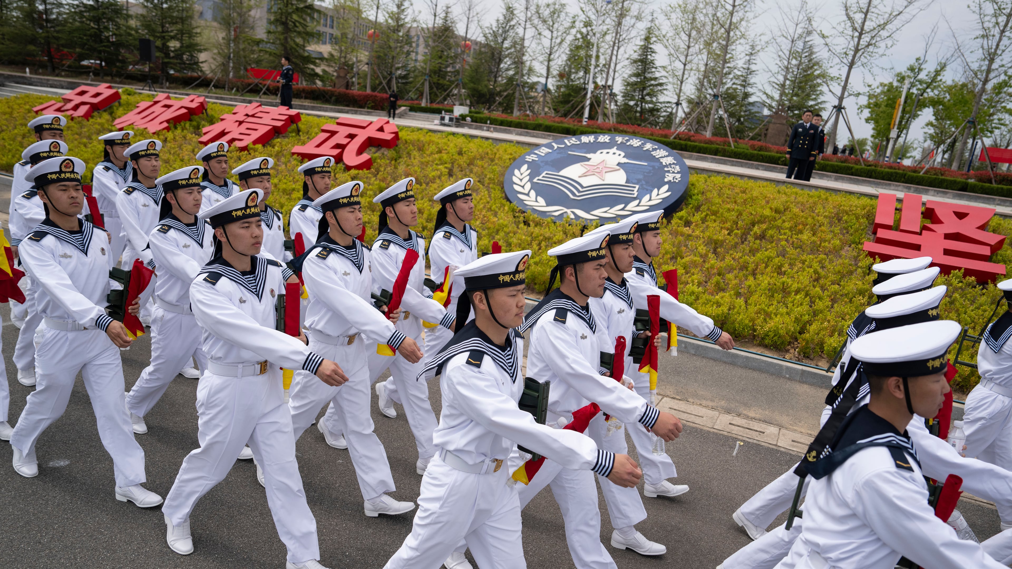FILE - Sailors march past the insignia for the People's Liberation Army (PLA)'s naval submarine academy during a tour arranged for foreign journalists a day before the opening of the West Pacific Naval Symposium in Qingdao in eastern China's Shandong province, Sunday, April 21, 2024. (AP Photo/Ng Han Guan, File)
