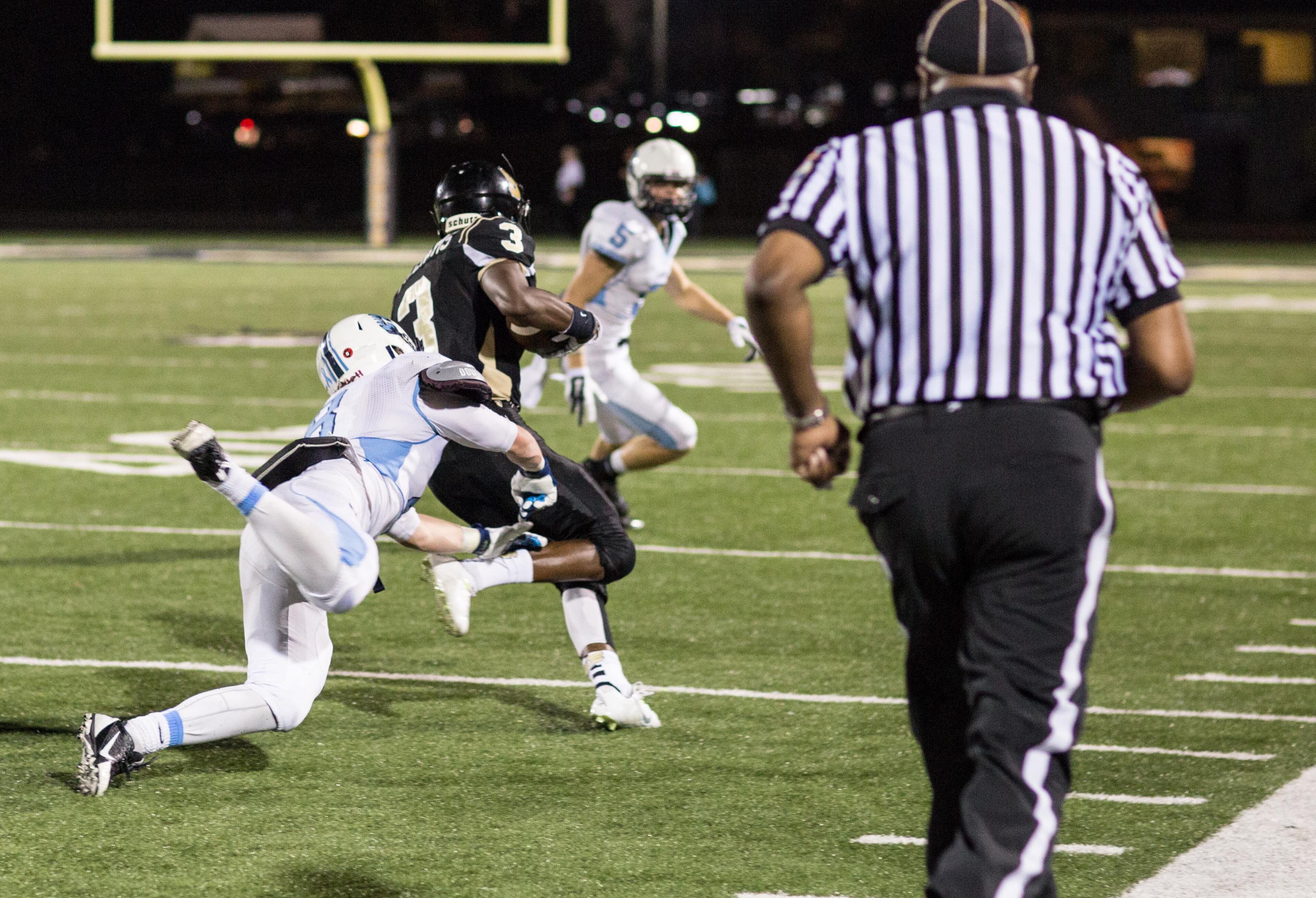 Cambridge High School's Charles Mills (8) dives after Sprayberry High School wide receiver Jontae Williams (3) in Marietta, Ga. Sprayberry defeated Cambridge 31-7. (SPECIAL/BRANDEN CAMP)