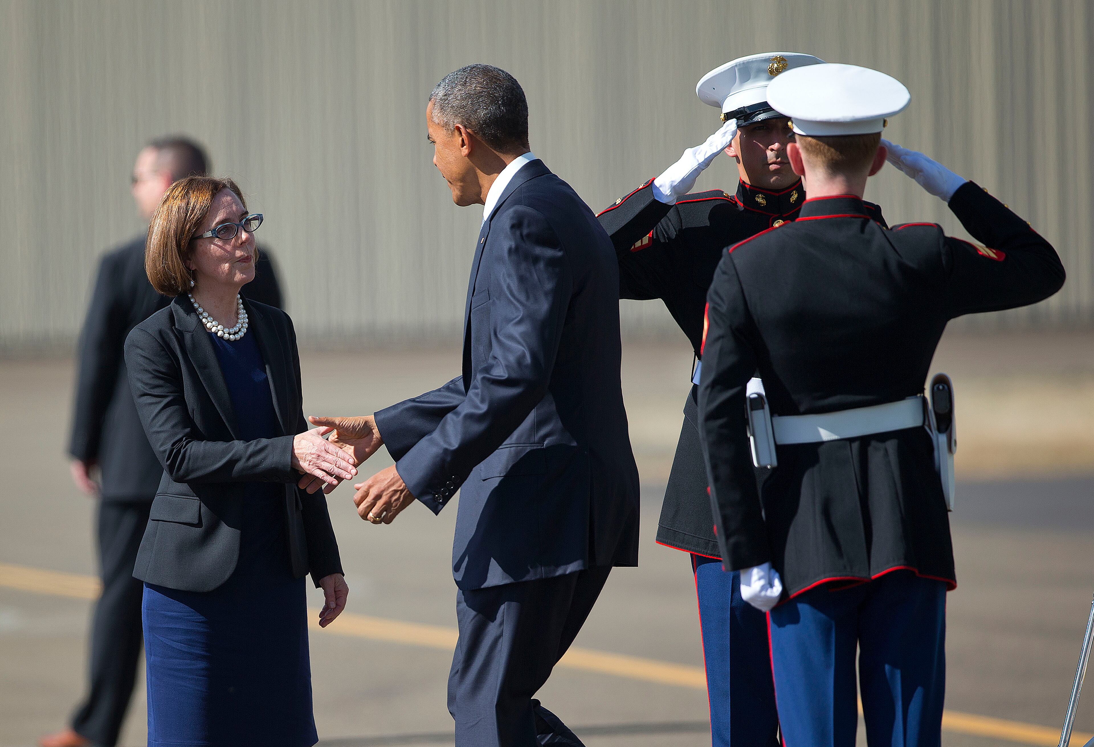 President Barack Obama is greeted on the tarmac by Oregon Gov. Kate Brown upon his arrival on Marine One helicopter at Roseburg Municipal Airport, Friday, Oct. 9, 2015 in Roseburg, Ore. Obama traveled to Roseburg to meet with families of the victims of the Oct. 1, shooting at Umpqua Community College, as part of a four-day West Coast tour. Obama is also scheduled to attend a fundraiser event later today in Seattle with Sen. Patty Murray, D-Wash. He's is also attending fundraisers in San Francisco and Los Angeles during the four-day visit. (AP Photo/Pablo Martinez Monsivais)