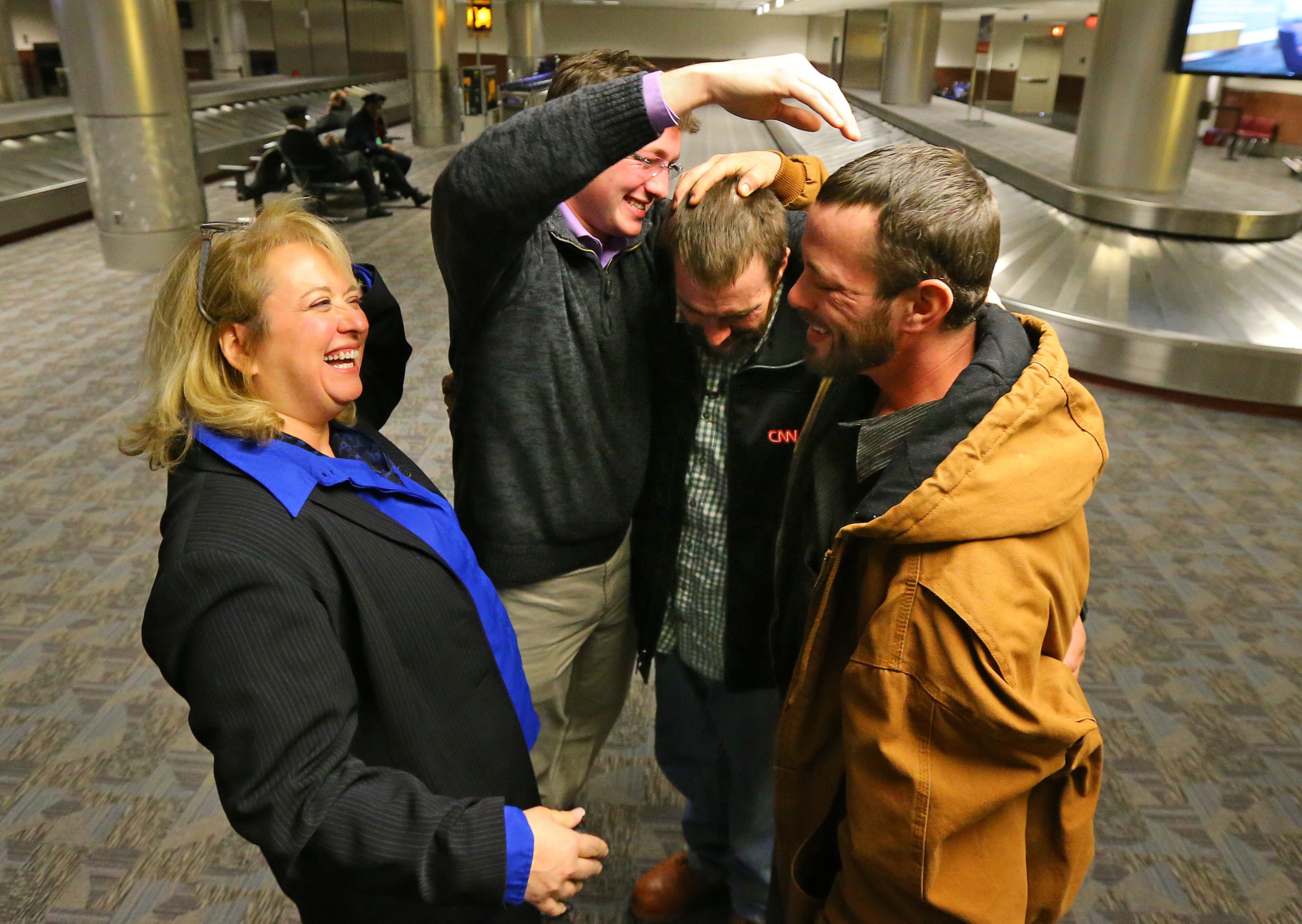 Joel Hartman is reunited with his family at Hartsfield Jackson Airport for Thanksgiving on Thursday, Nov. 28, 2013, in Atlanta. His stepmother Deanna Rodecki (from left), brother Andrew Rodecki, Joel Hartman, and his brother Erick Hordos joyfully embrace at baggage claim for the first time in a decade. Deanna Rodecki has been searching for Hartman for more than 10 years catching wind of him only to find he had moved on.