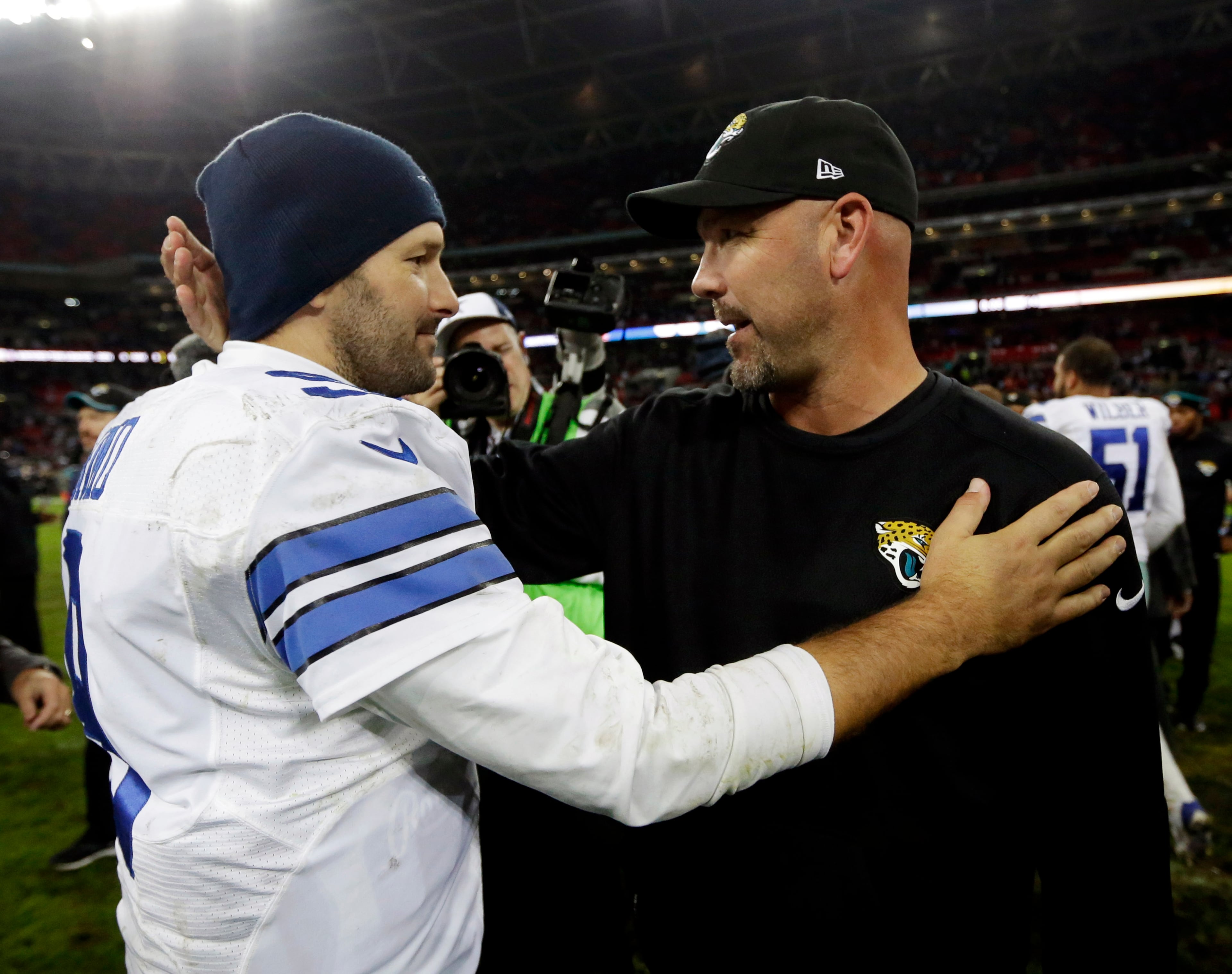 Dallas Cowboys quarterback Tony Romo talks to Jacksonville Jaguars head coach Gus Bradley following their NFL football game at Wembley Stadium, London, Sunday, Nov. 9, 2014. The Cowboys defeated the Jaguars 31-17. (AP Photo/Matt Dunham)