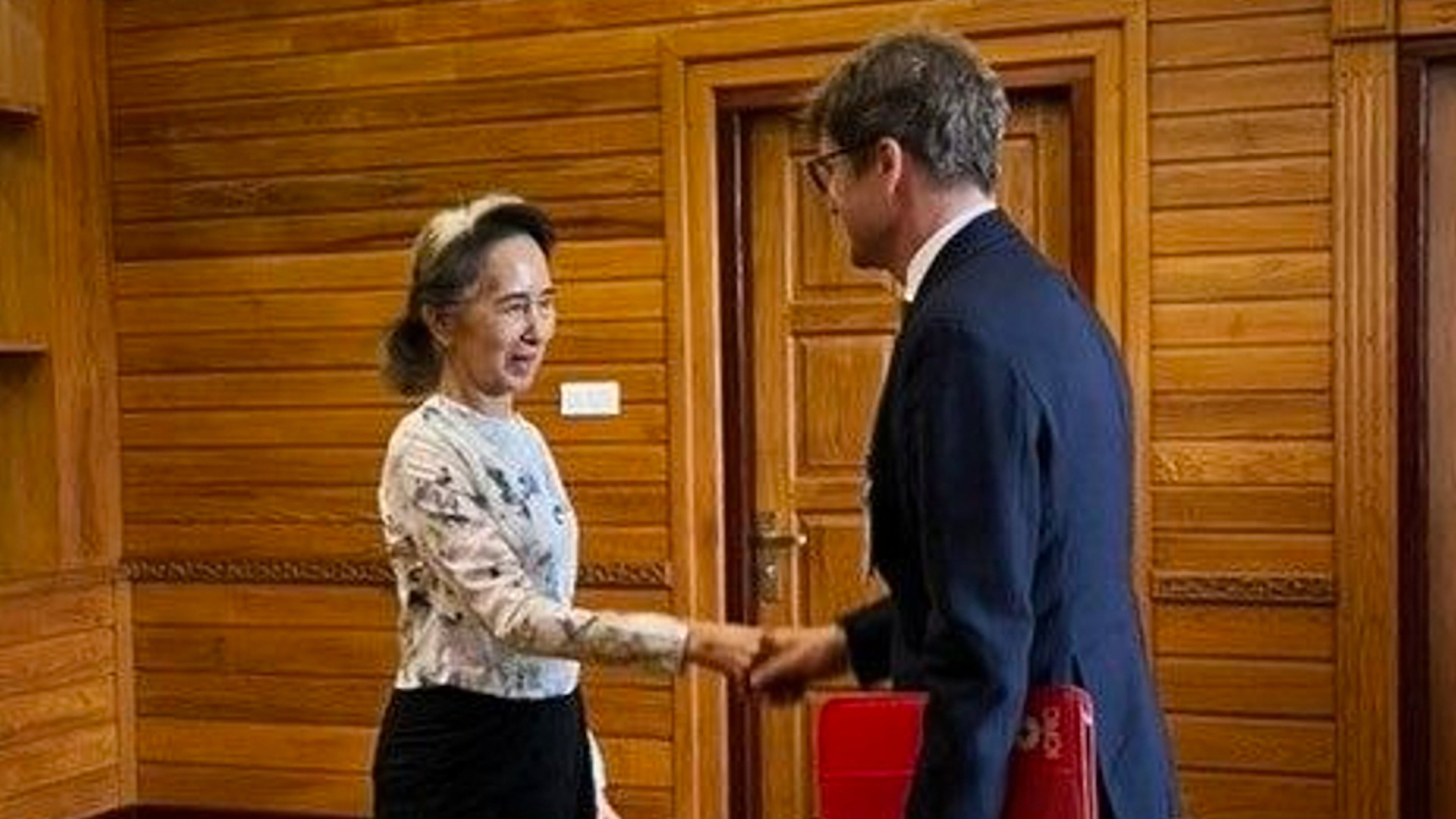 In this photo released by Myanmar President Office on Monday, Aug. 3, 2026, Myanmar's ousted leader Aung San Suu Kyi, left, shakes hands with Arnaud de Baecque, resident representative of the International Committee of the Red Cross, during their meeting in Naypyitaw, Myanmar. (Myanmar President Office via AP)