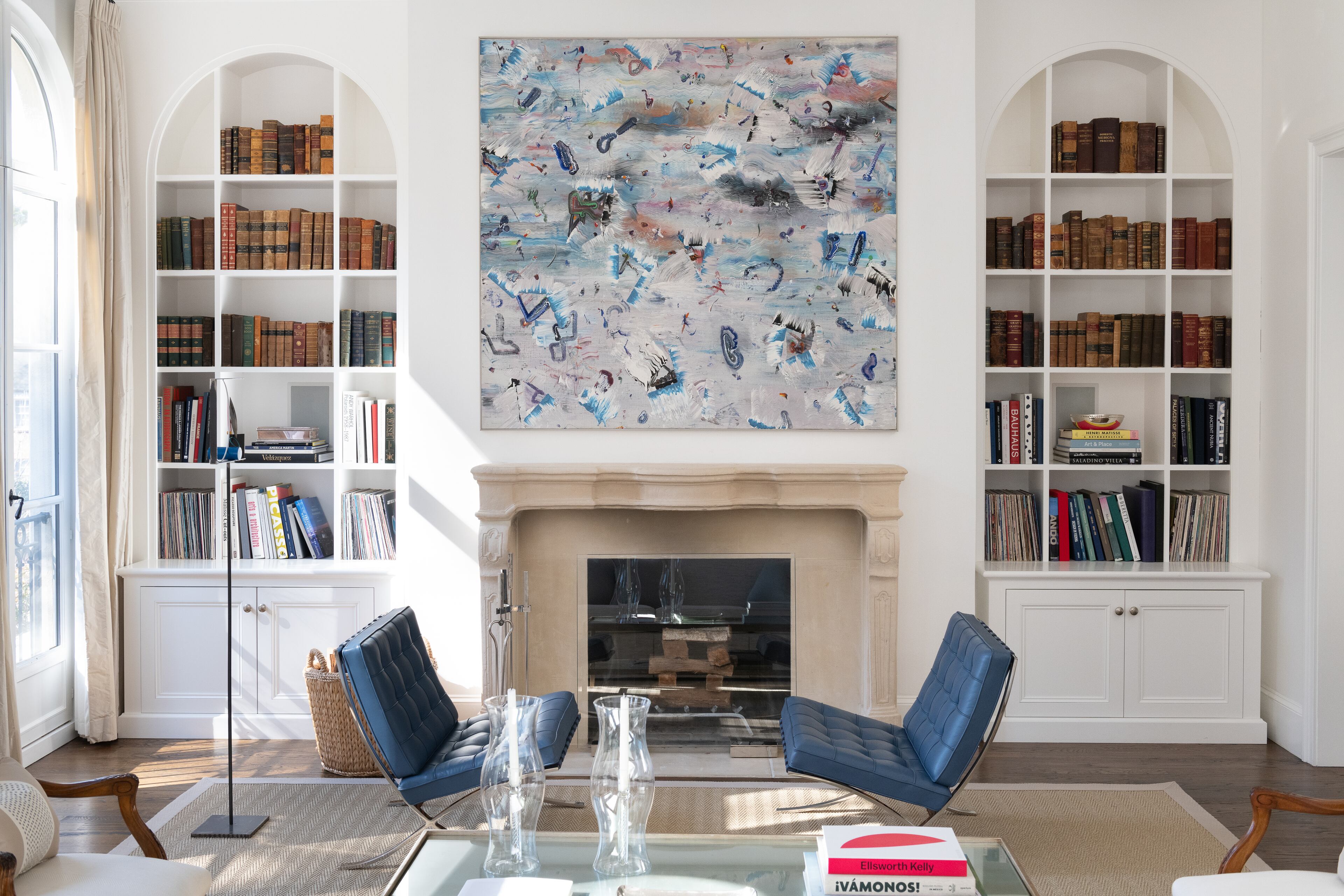 Built-in bookcases flank the limestone fireplace. The undulating lines on the mantel add a softness to the natural stone. Text by Ansley Warren