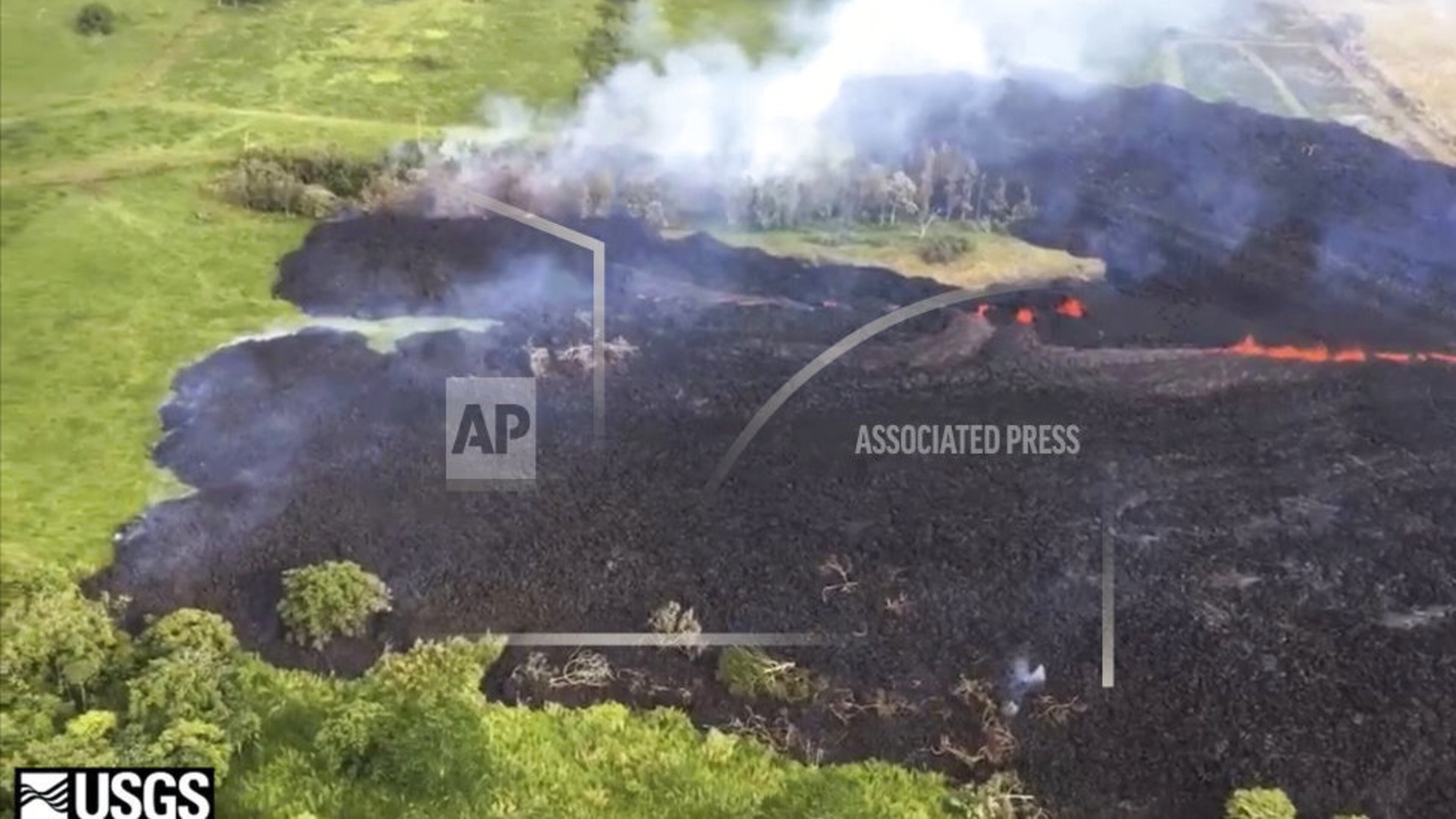 In this May 13, 2018 frame from video released by the U.S. Geological Survey, gases rise from a fissure near Pahoa, Hawaii. The new fissure sent gases and lava exploding into the air, spurring officials to call for more evacuations as residents waited for a possible major eruption at Kilauea volcano's summit. (U.S. Geological Survey via AP)