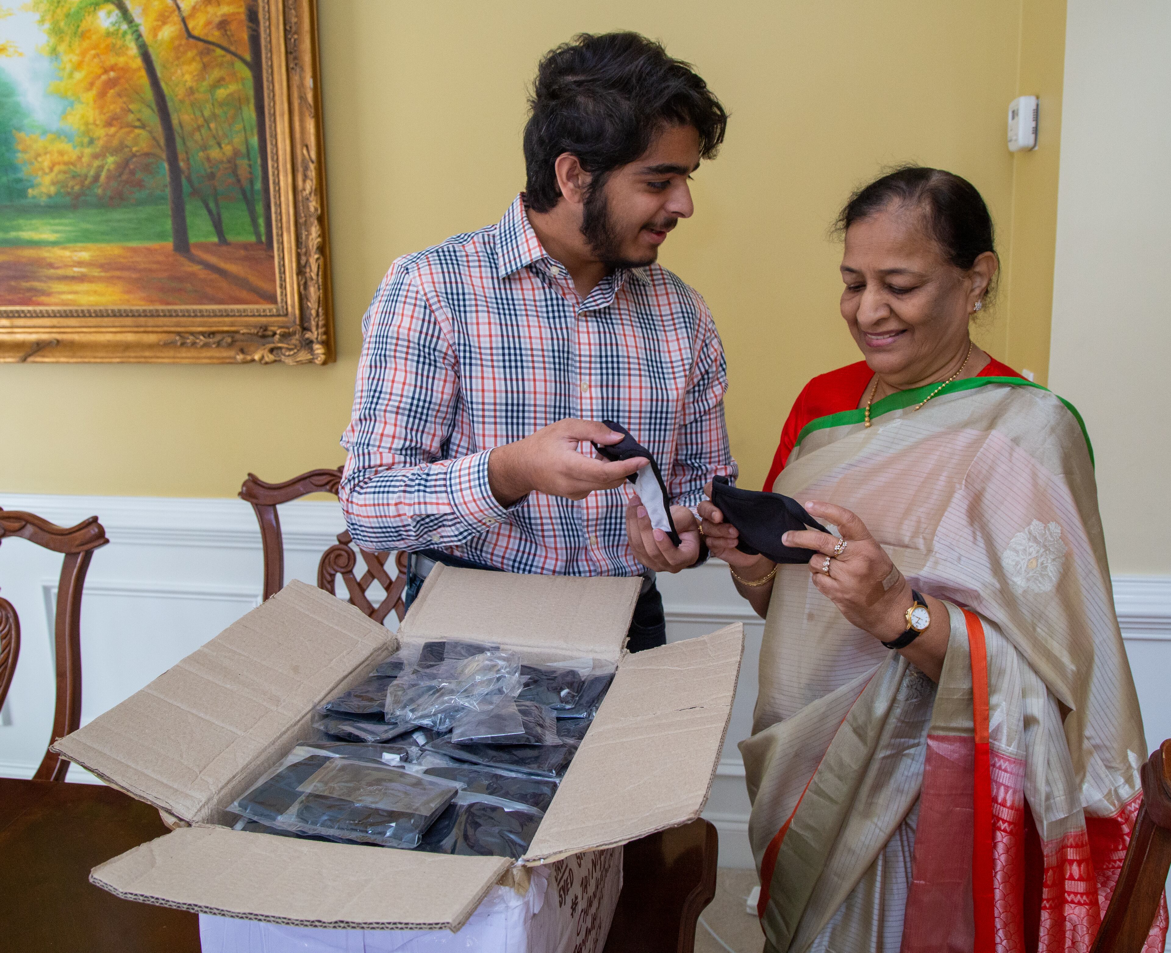 Westminster School senior Azeez Ishaqui (left) and his grandmother Najma look through a box of face masks that just arrived in their Smyrna home. During the pandemic Azeez came up with an idea to have women from India sew face masks that he would donate to homeless shelters in metro Atlanta. His Grandmother helped him accomplish that with her connections there. He was a high school freshman when he started helping the poor in India, first providing carts for men selling goods, and then later providing sewing machines for widows so they could earn a living. His parents are both from India, and he has always been encouraged to help the poor there. PHIL SKINNER FOR THE ATLANTA JOURNAL-CONSTITUTION.