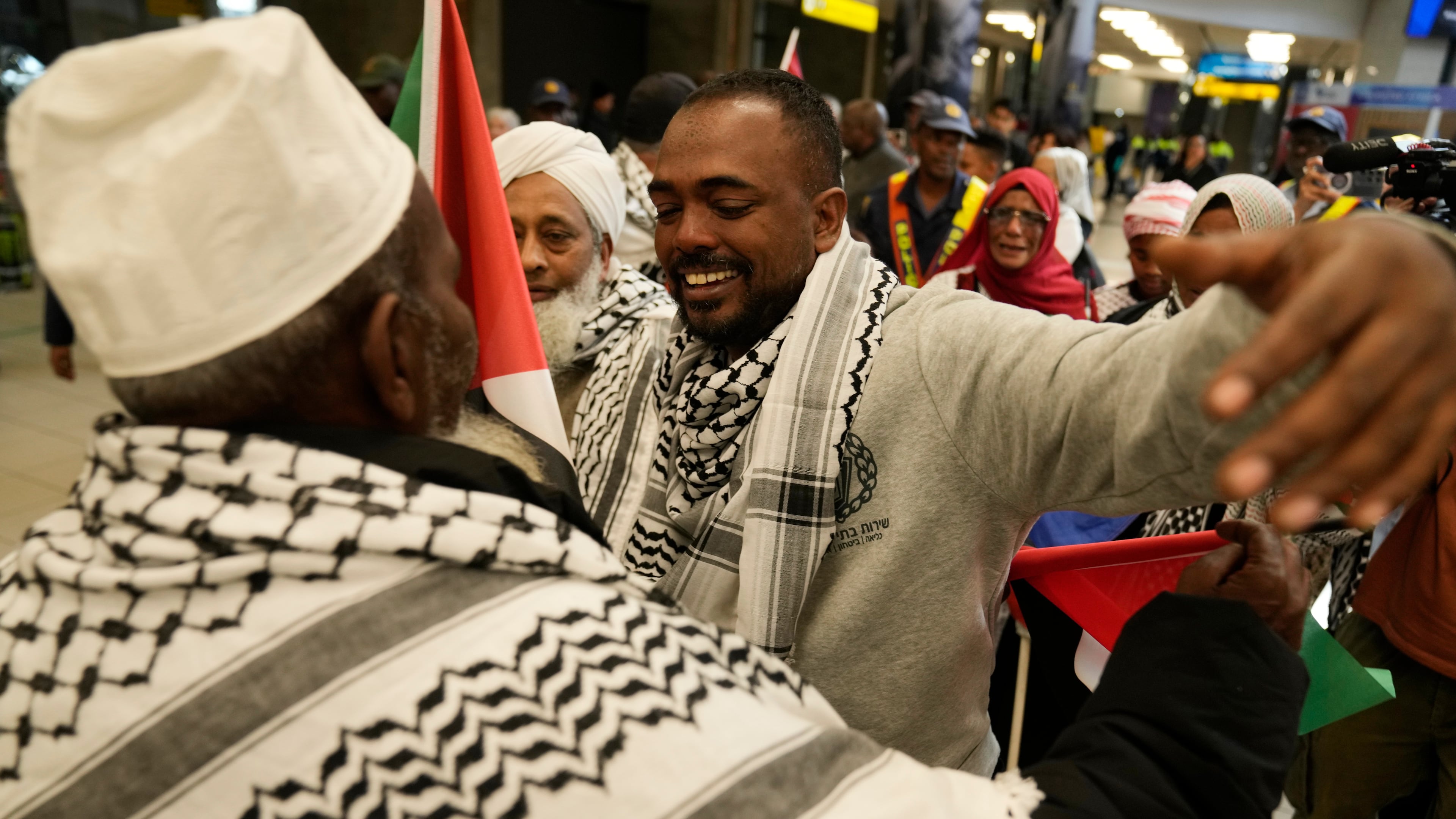 Ebrahim Peters, right, an activist embraces his family member after returning home at OR Tambo International Airport, in Johannesburg, South Africa, Saturday, May 23, 2026. (AP Photo/Themba Hadebe)
