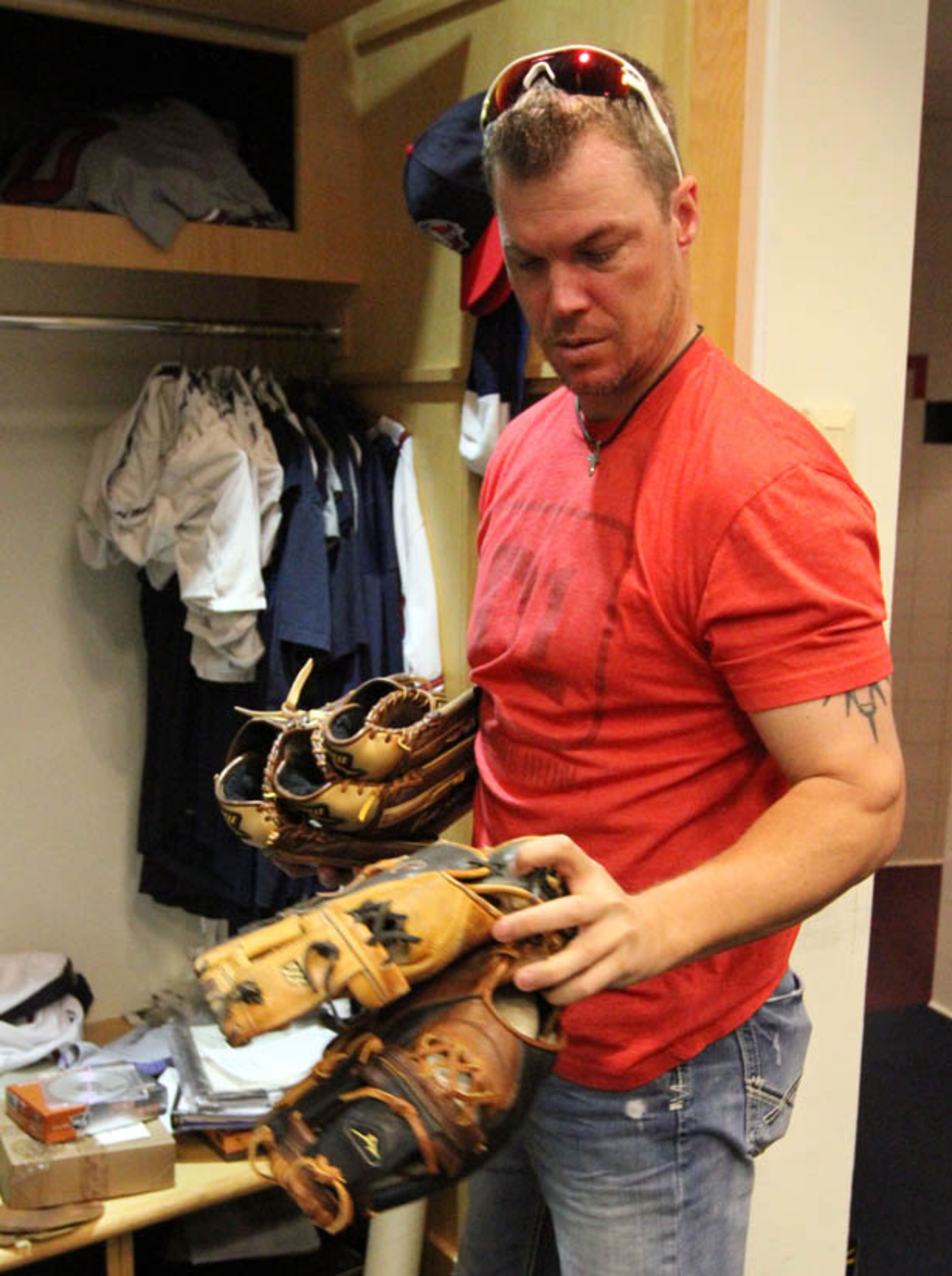 Chipper Jones sorts through his gloves as he packs up his belongings in the Braves clubhouse at Turner Field.