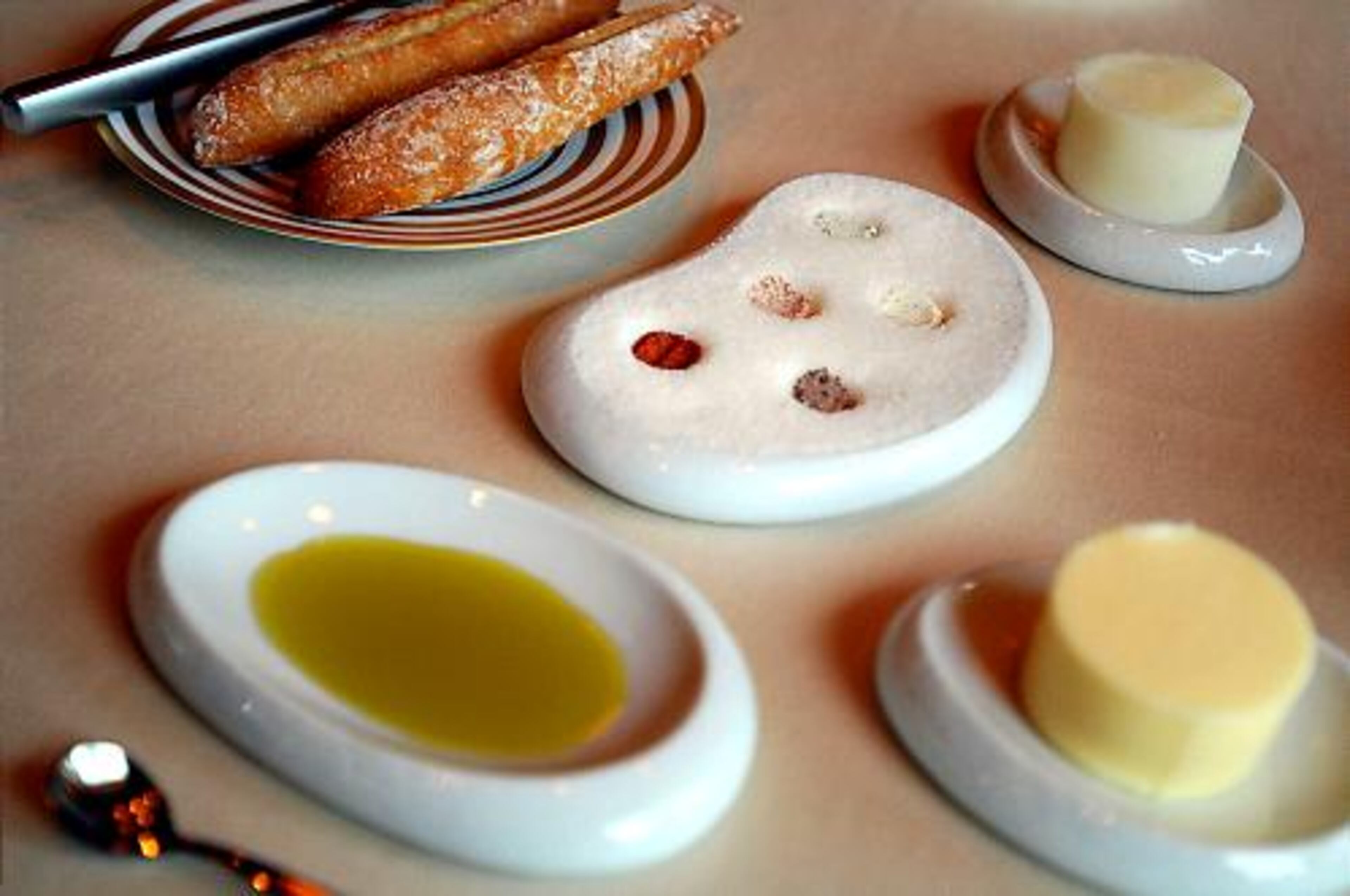 An arrangement of butter, salts, olive oil and bread. What had been a shabby chic restaurant has become sleek.