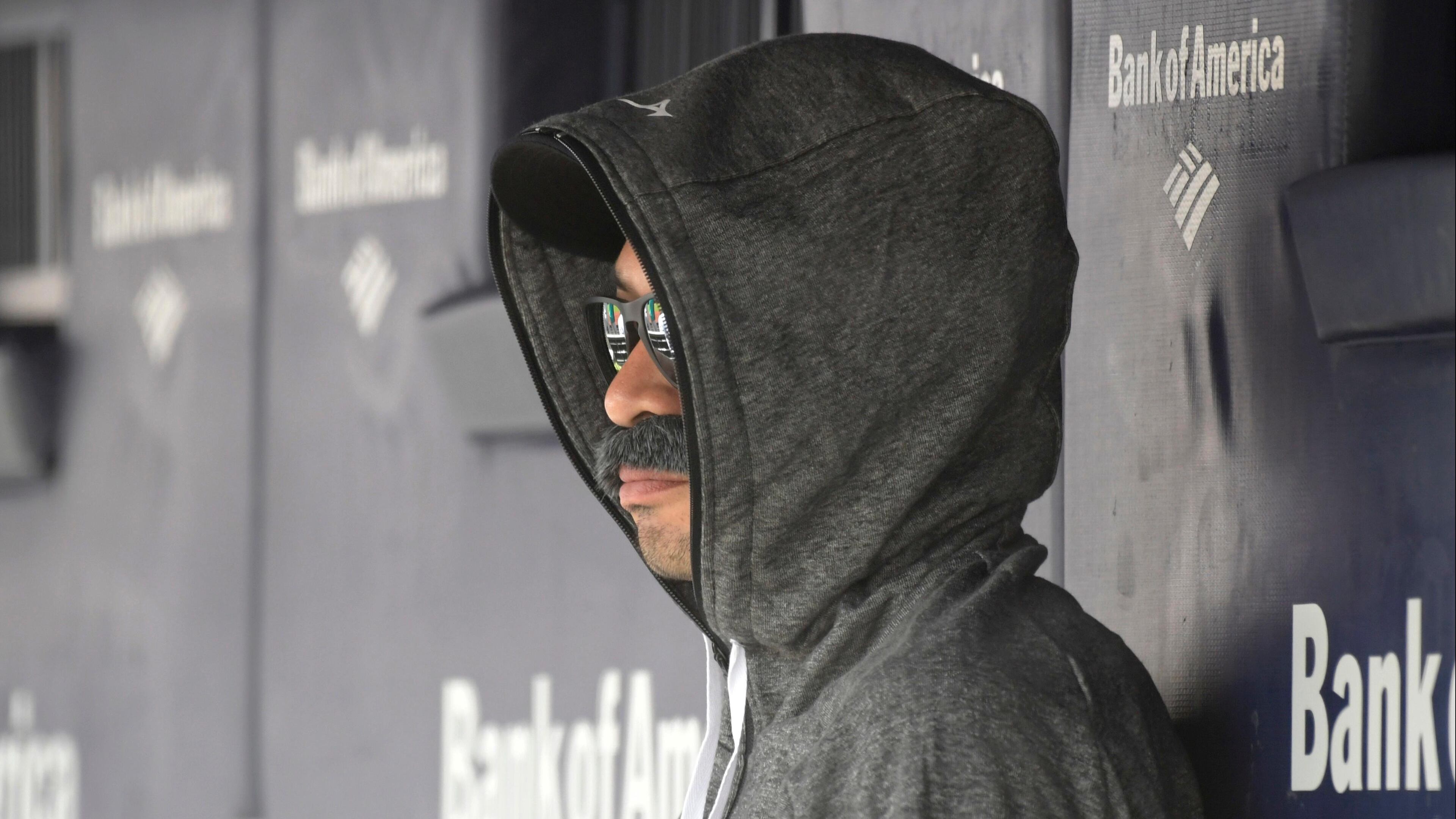 Ichiro Suzuki, special assistant to the chairman of the Seattle Mariners, wears a fake mustache and a hoodie as he sits in the dugout and watches the New York Yankees bat during the first inning of Thursday's baseball game.