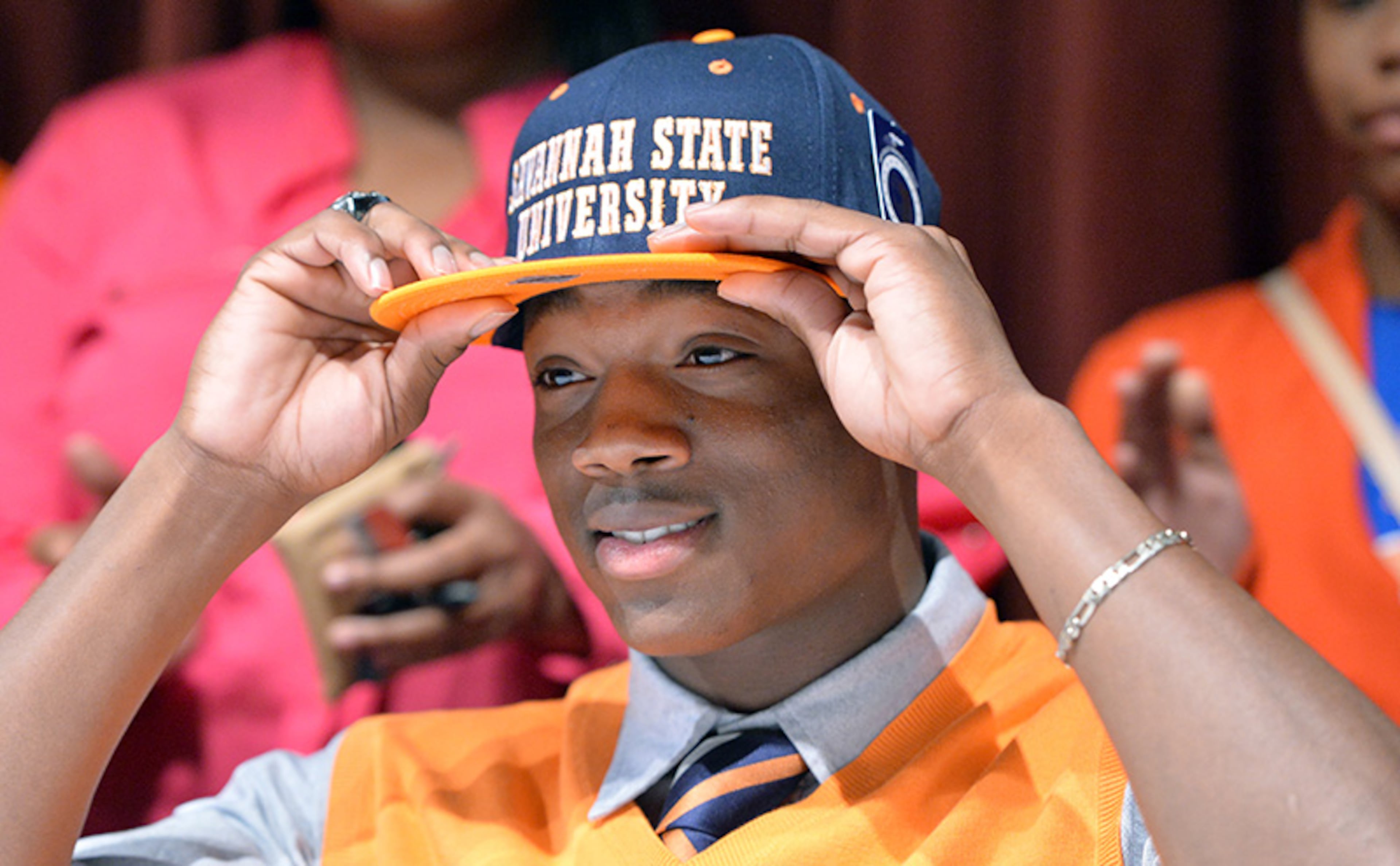Stephen Reynolds puts on a hat from Savannah State during signing day at Tucker High School.