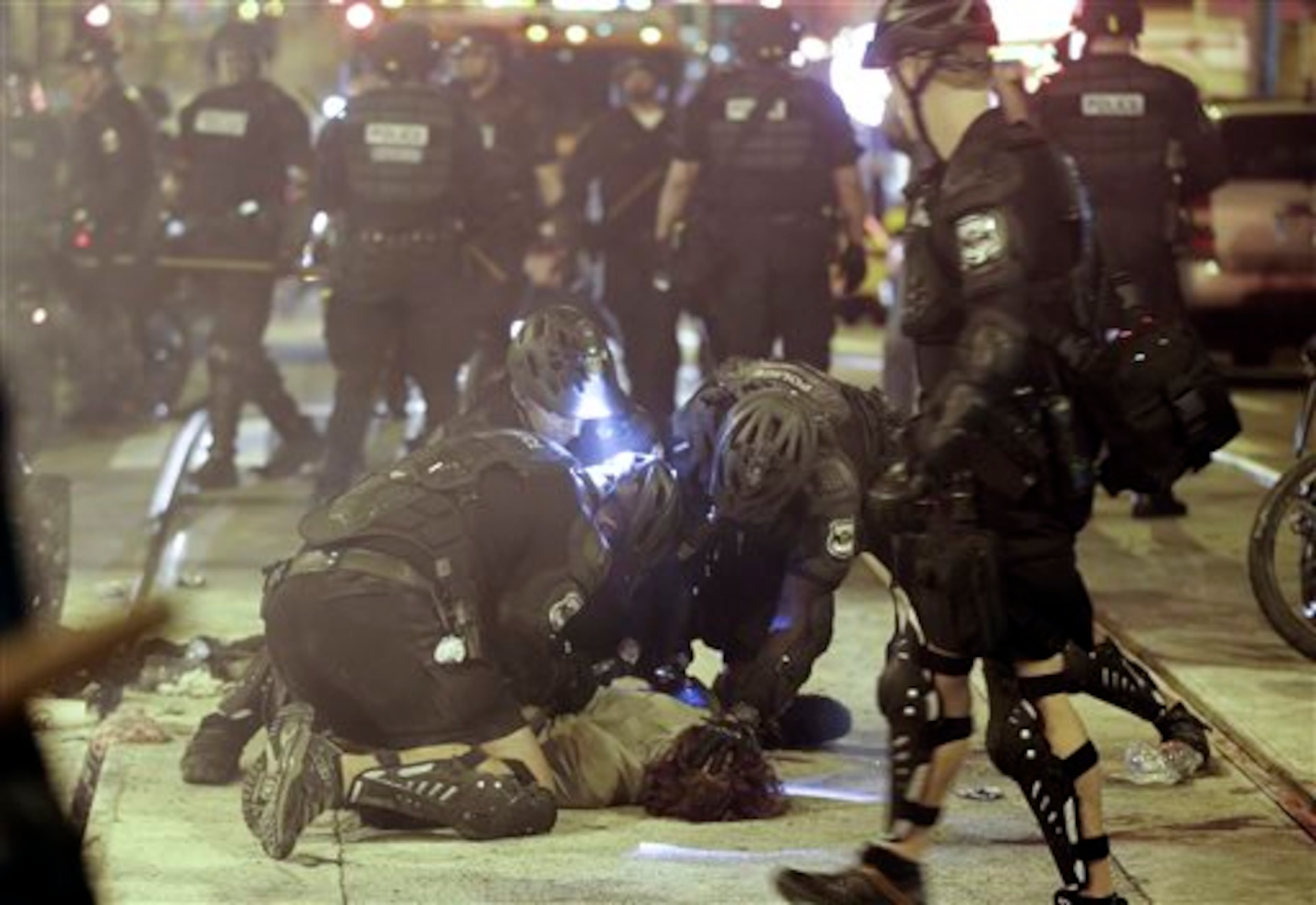 Police detain a protester during May Day activities Thursday, May 1, 2014 in Seattle. Police have made several arrests and fired pepper spray as anti-capitalist marchers meandered through Seattle several hours after hundreds of peaceful demonstrators took part in a May Day march in support of immigrant rights and a boost in the minimum wage. (AP Photo/Ted S. Warren)