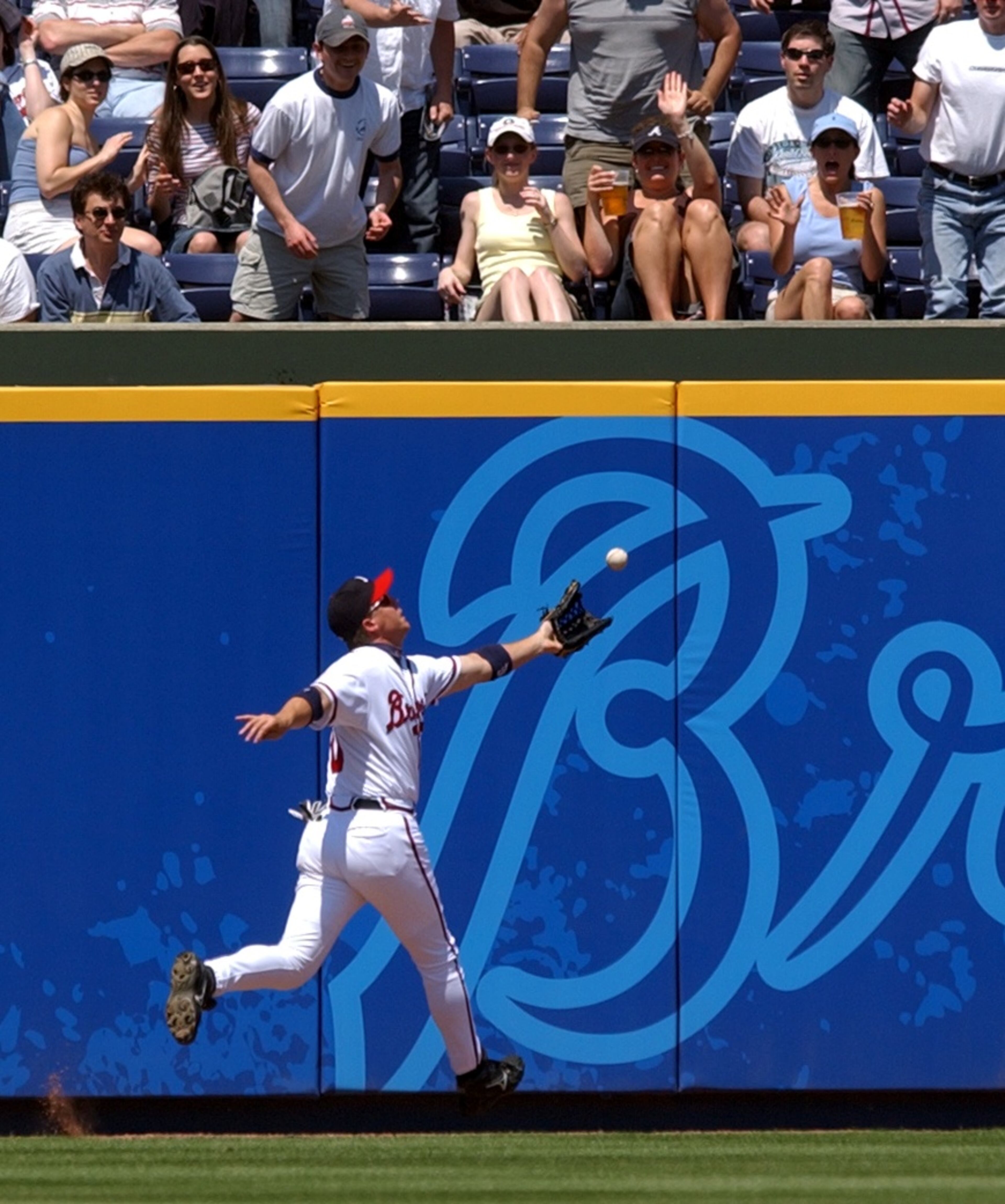 Chipper Jones of the Braves goes to the wall to try to catch a fly ball hit by Florida Marlin Luis Castillo in the 6th inning Sunday April 18, 2004. (JEAN SHIFRIN/staff)
