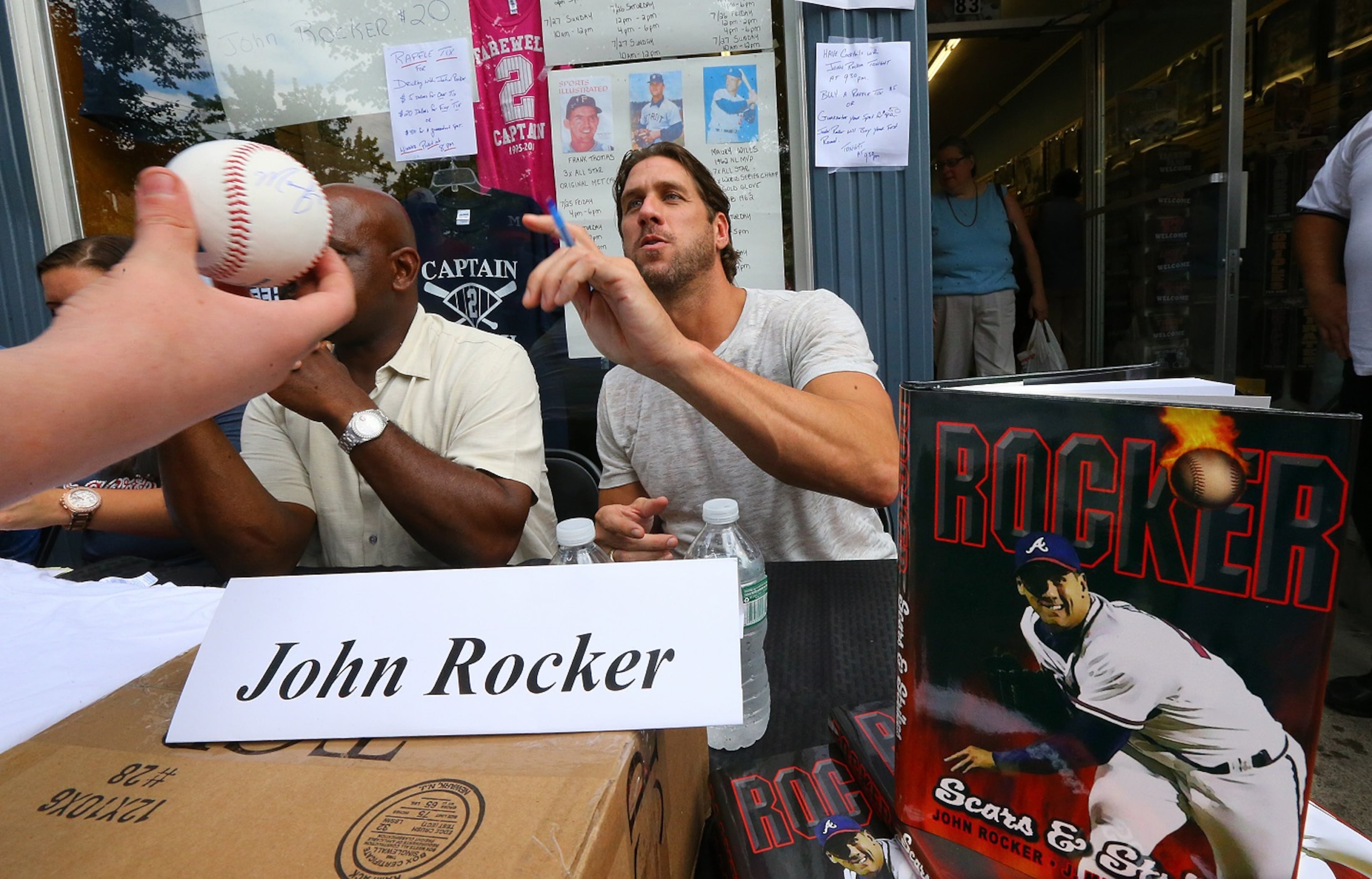 Former Braves pitcher John Rocker autographs a baseball for a Braves fan while signing on Main Street on Saturday, July 26, 2014, in Cooperstown. CURTIS COMPTON / CCOMPTON@AJC.COM