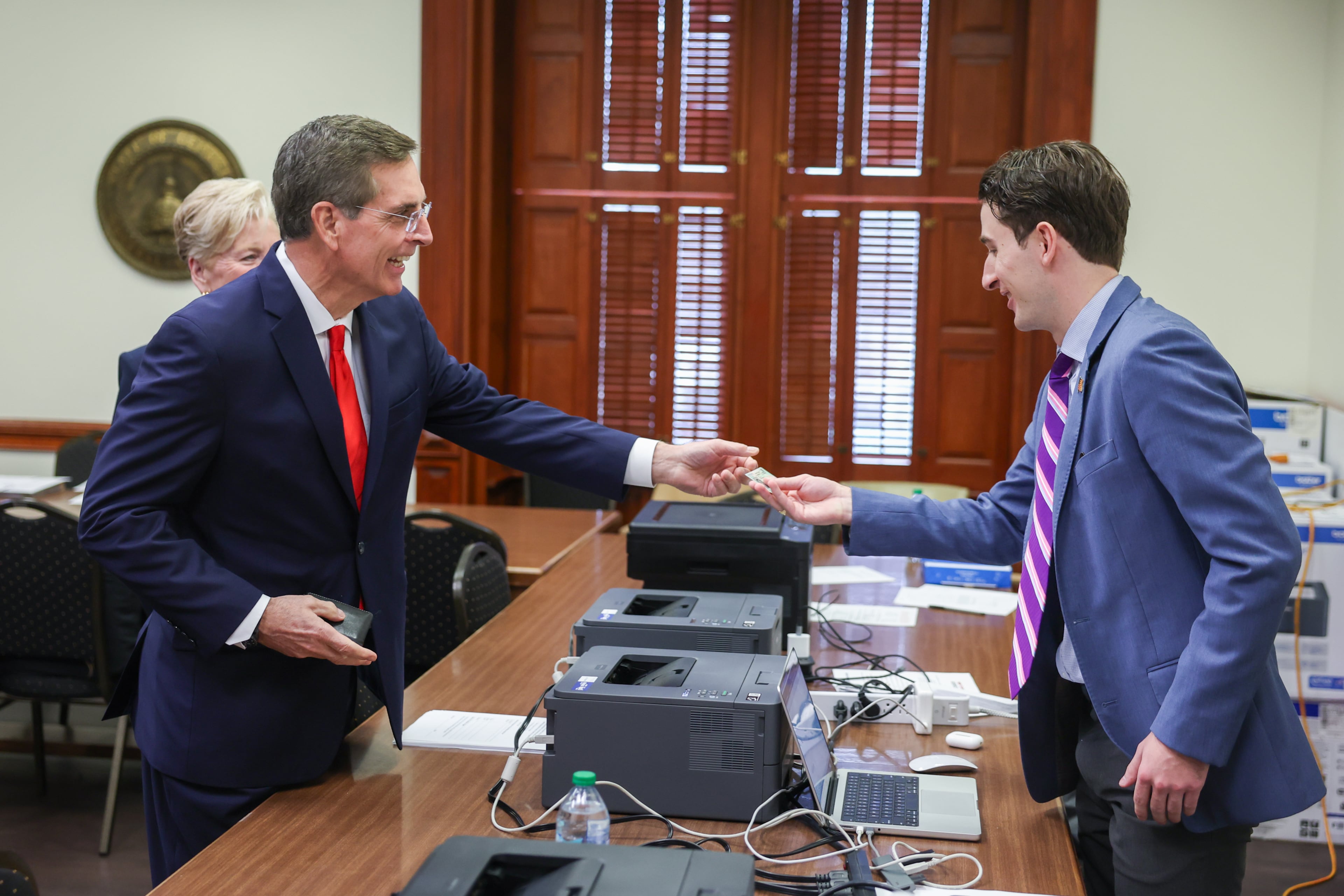 Secretary of State Brad Raffensperger (left) files paperwork Friday to run for governor of Georgia. (Arvin Temkar/AJC)