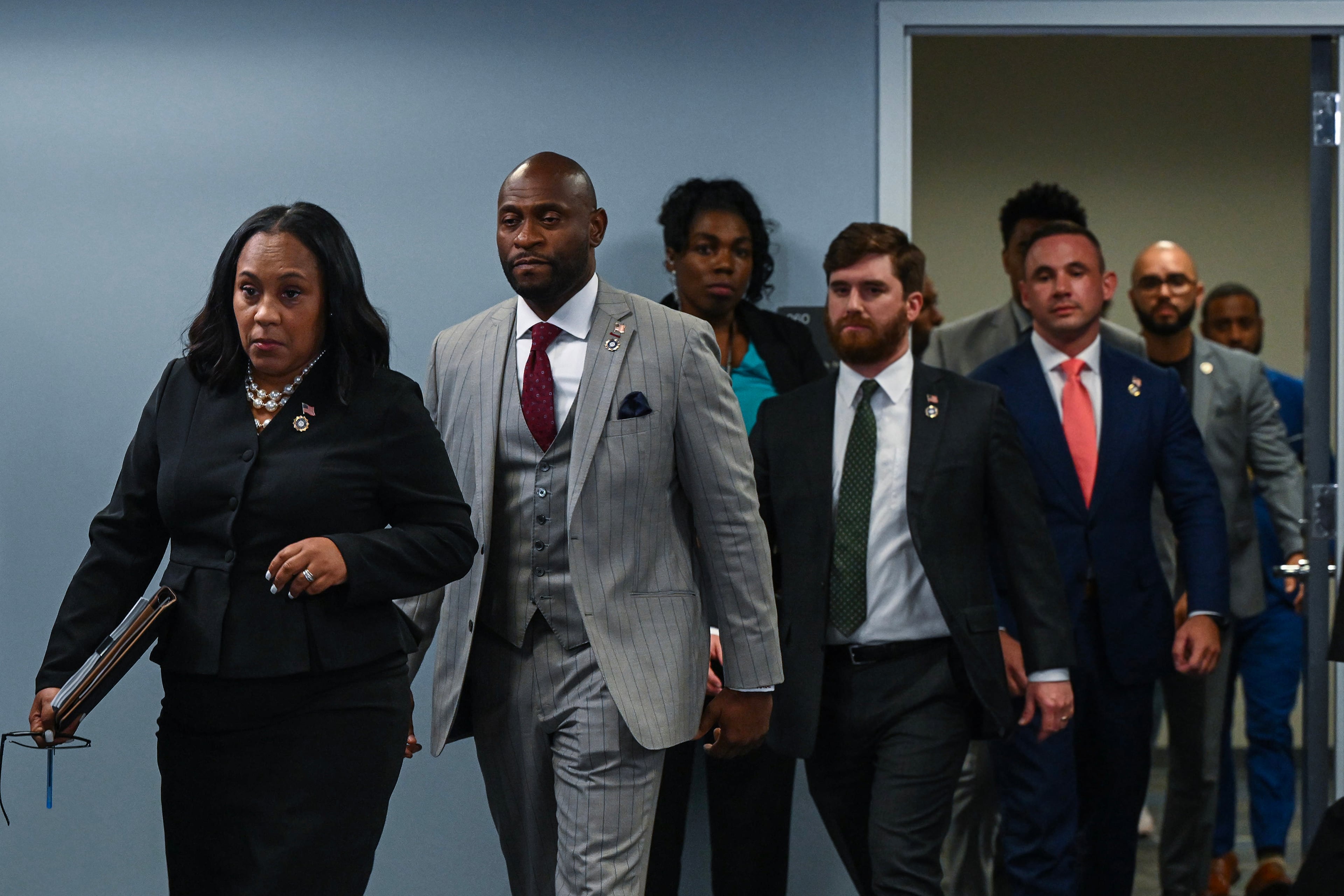 FILE — Fulton County District Attorney Fani Willis, left, is followed by the special prosecutor Nathan Wade as they arrive at a news conference in Atlanta on Aug. 14, 2023. An Atlanta judge on Friday, March 15, 2024, ruled that Willis could continue leading the prosecution of former President Donald Trump and his allies in Georgia, but only if Wade, her former romantic partner, withdraws as the lead prosecutor of the case. (Kenny Holston/The New York Times)
