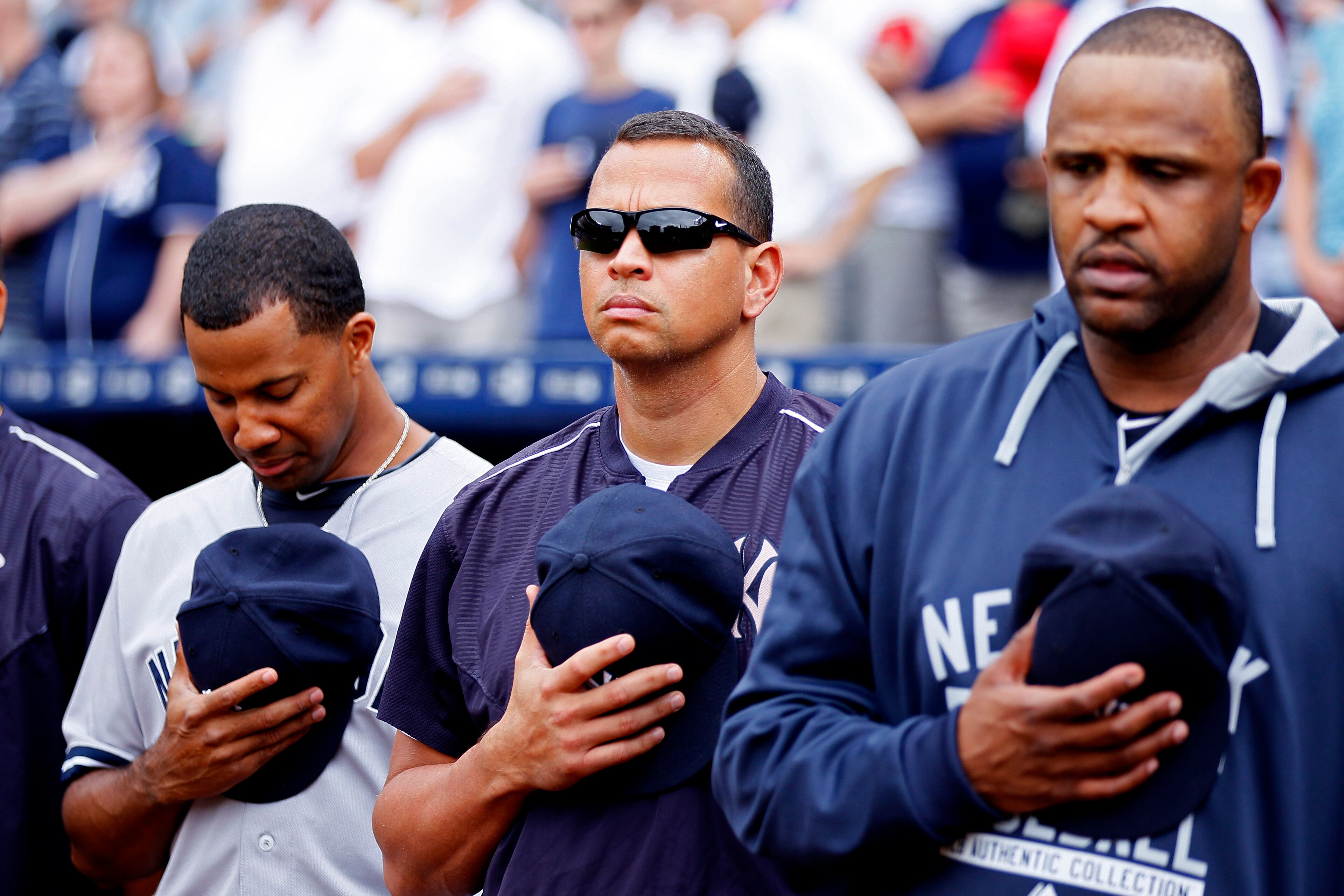 New York Yankees' Alex Rodriguez, center, appears during a moment of silence honoring a fan who died Saturday during a baseball game against the Atlanta Braves, Sunday, Aug. 30, 2015, in Atlanta. (AP Photo/Todd Kirkland)