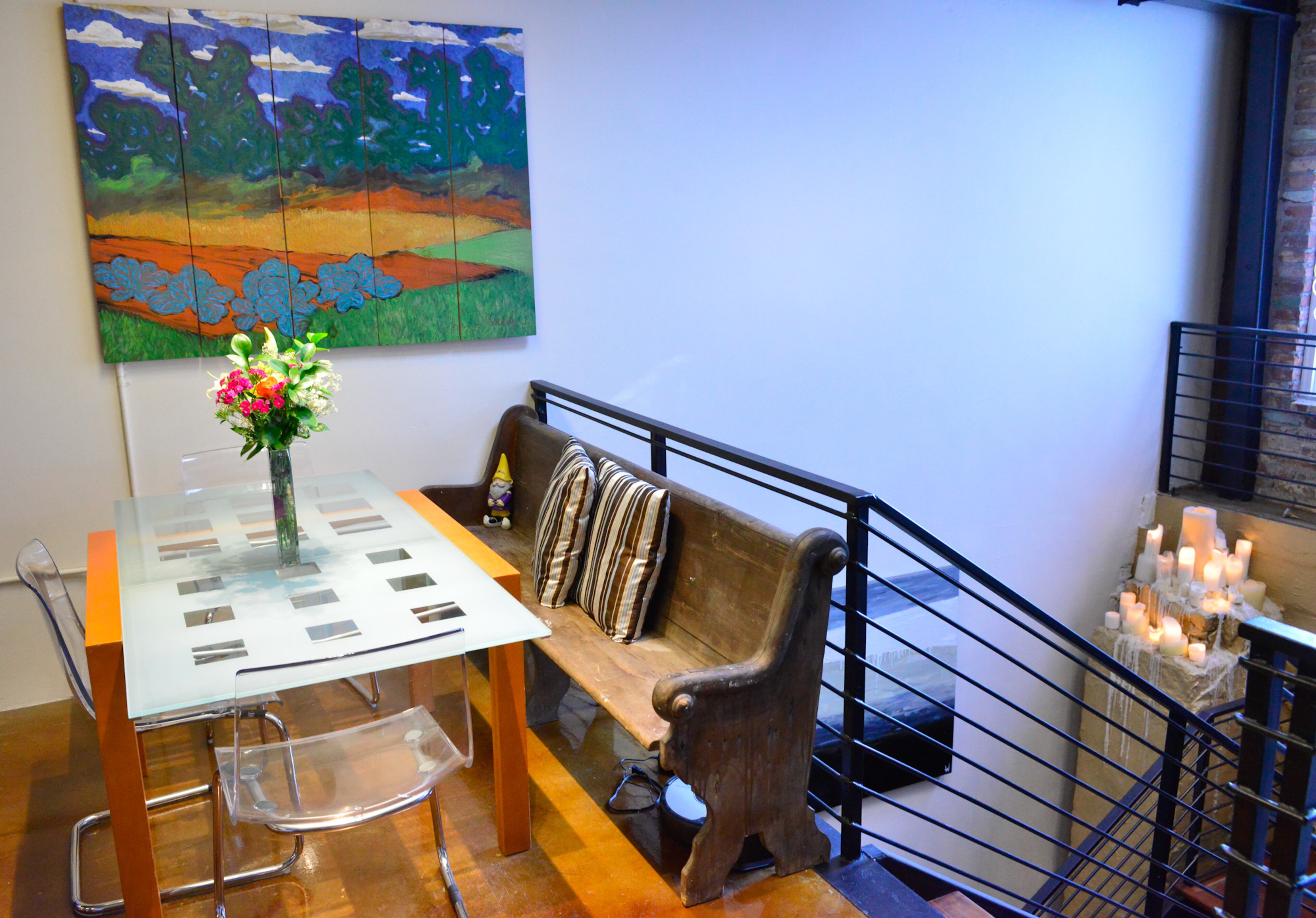 On both sides of a Lignet Roset table - purchased from an interior designer friend - old meets new as Betsy Walsh paired a church pew with acrylic chairs from IKEA. A painting on wood boards by the late Georgia folk artist Jon Whiddon hangs above the dining table.