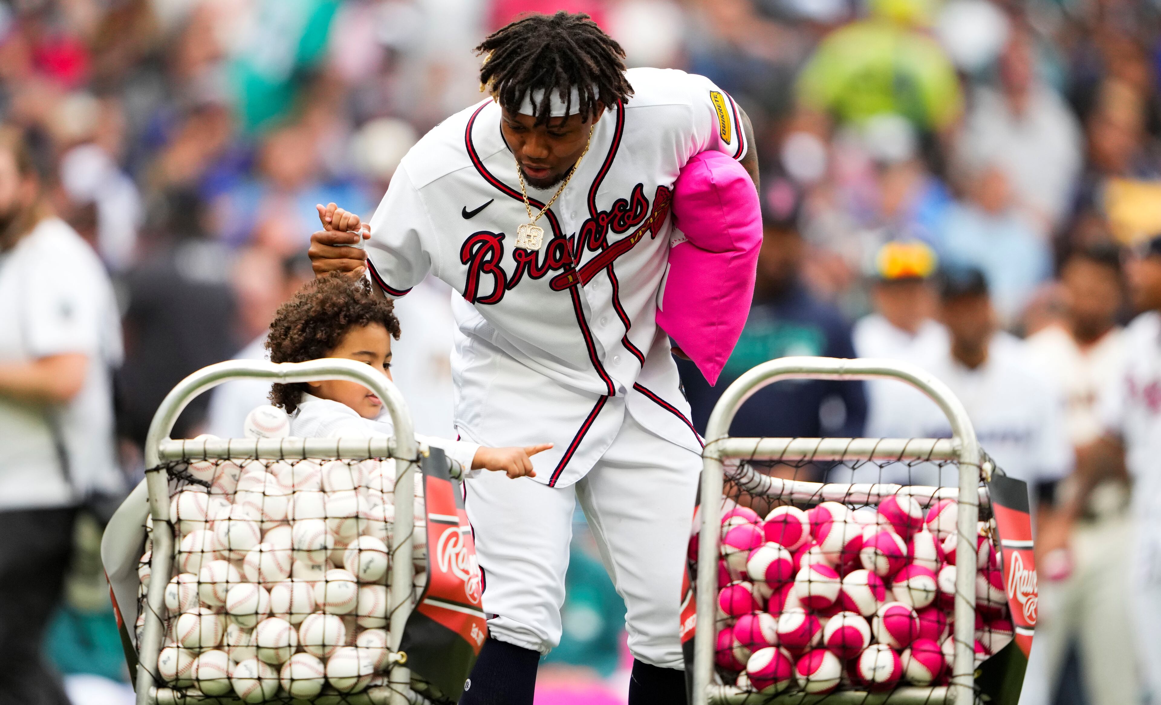 Ronald Acuna Jr. walks by a pair of baseball baskets Monday between rounds of the home run derby in Seattle. Acuna will start for the National League Tuesday against the American League in the MLB All-Star game. (AP Photo/Lindsey Wasson)