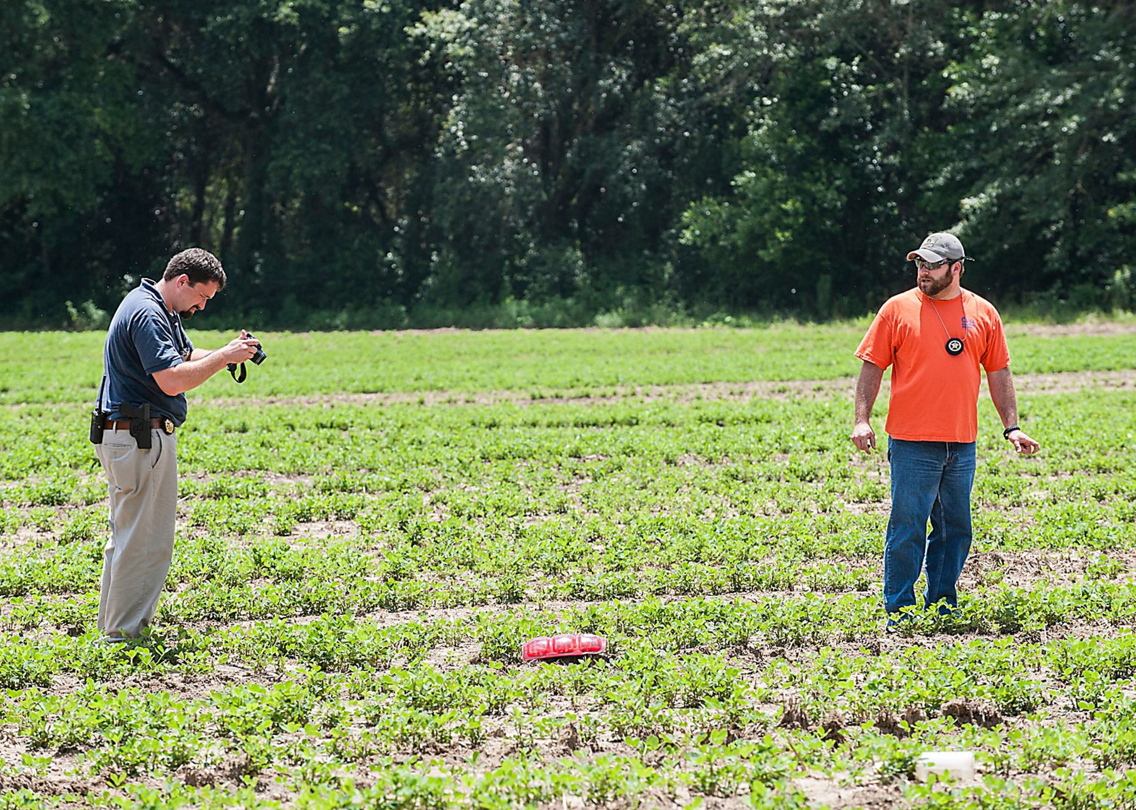 Members of the Brooks County Sheriff's department document a taillight from the wreckage found 80 feet from the wreckage in a field next to the roadway.