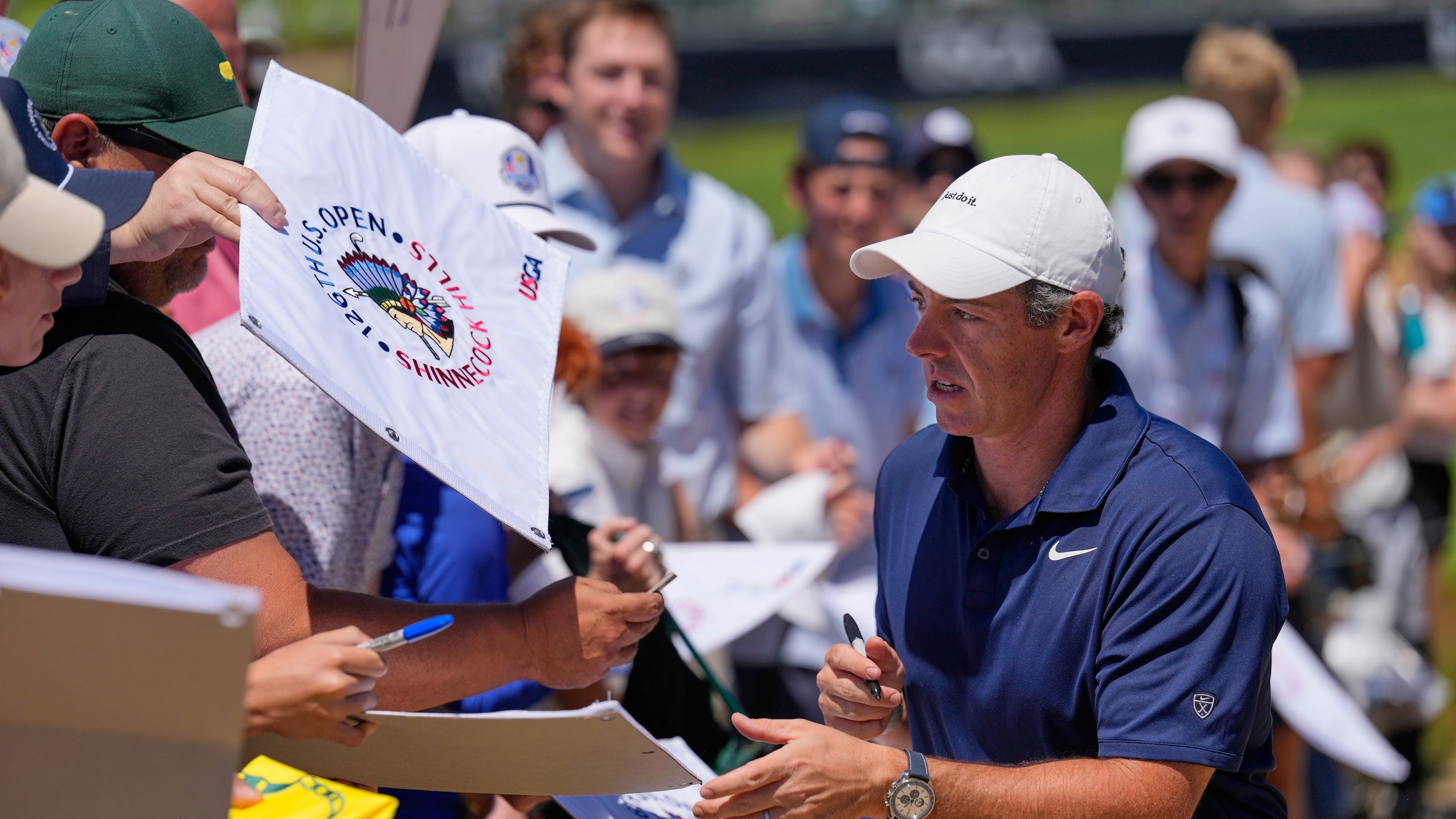 Rory McIlroy, of Northern Ireland, signs autographs during a practice round for the U.S. Open golf tournament at Shinnecock Hills Golf Club in Southampton, N.Y., Monday, June 15, 2026.(AP Photo/David J. Phillip)