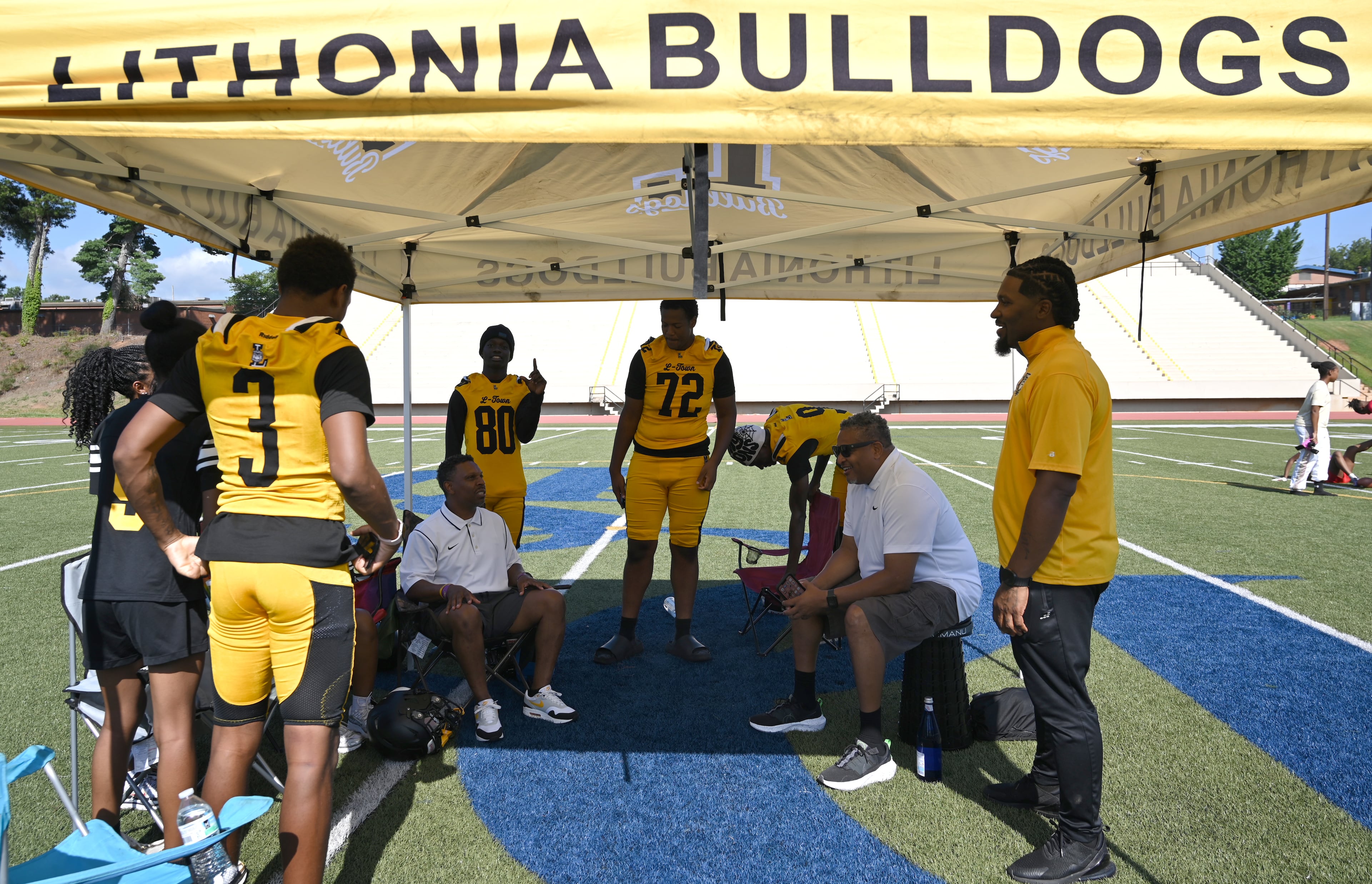 Lithonia football’s transformation began when coach Kevin Barnes (standing at right) arrived in 2024 and led the Bulldogs to a 6-4 record. (Hyosub Shin/AJC)