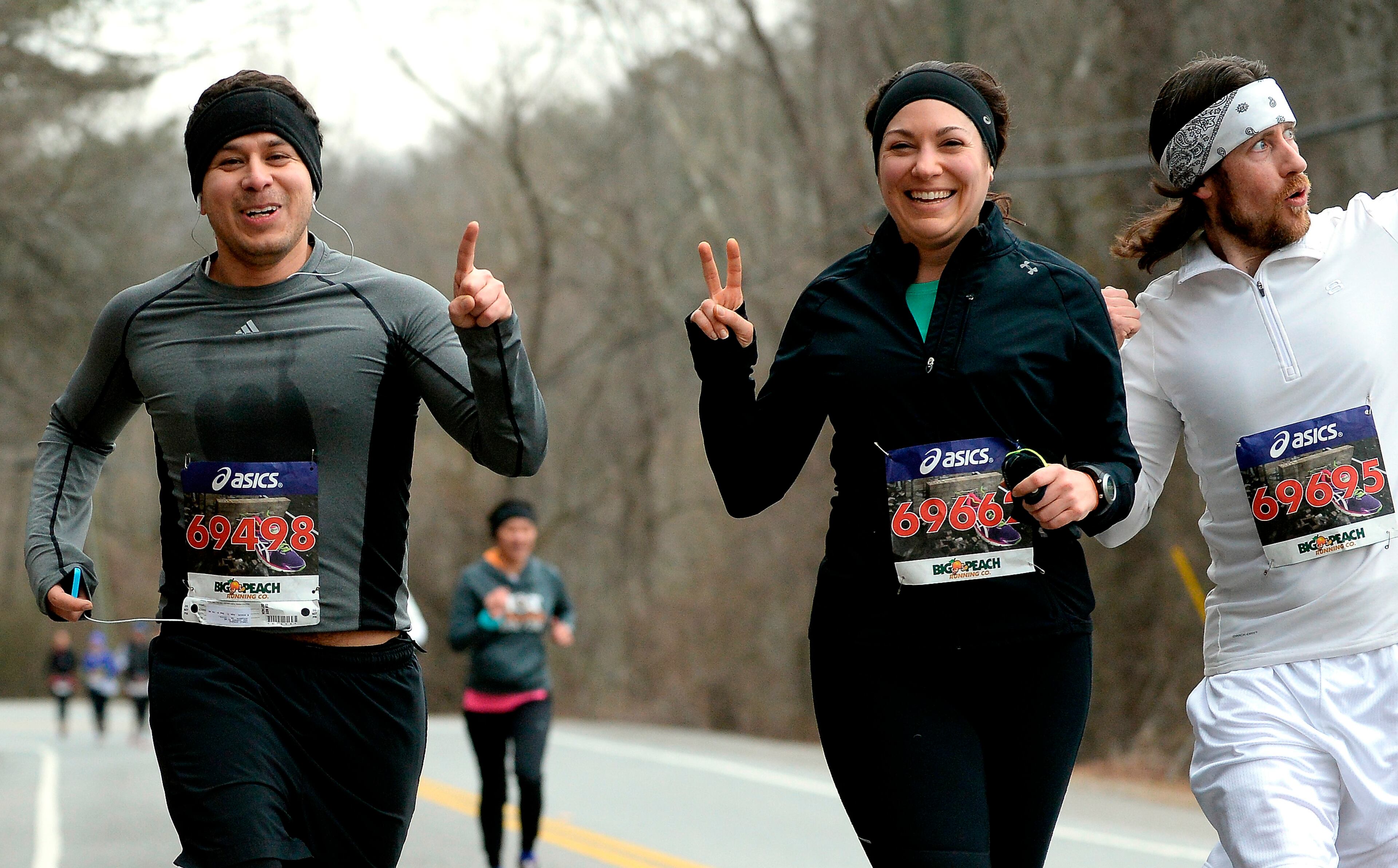 Runners Carlo Guerra, left, Bibi Nunez and Aaron Powell, right, clown around during the final mile of the 13th annual Chattahoochee Challenge 10K running race on Saturday, Feb. 8, 2014, in Roswell, Ga. David Tulis / AJC Special
