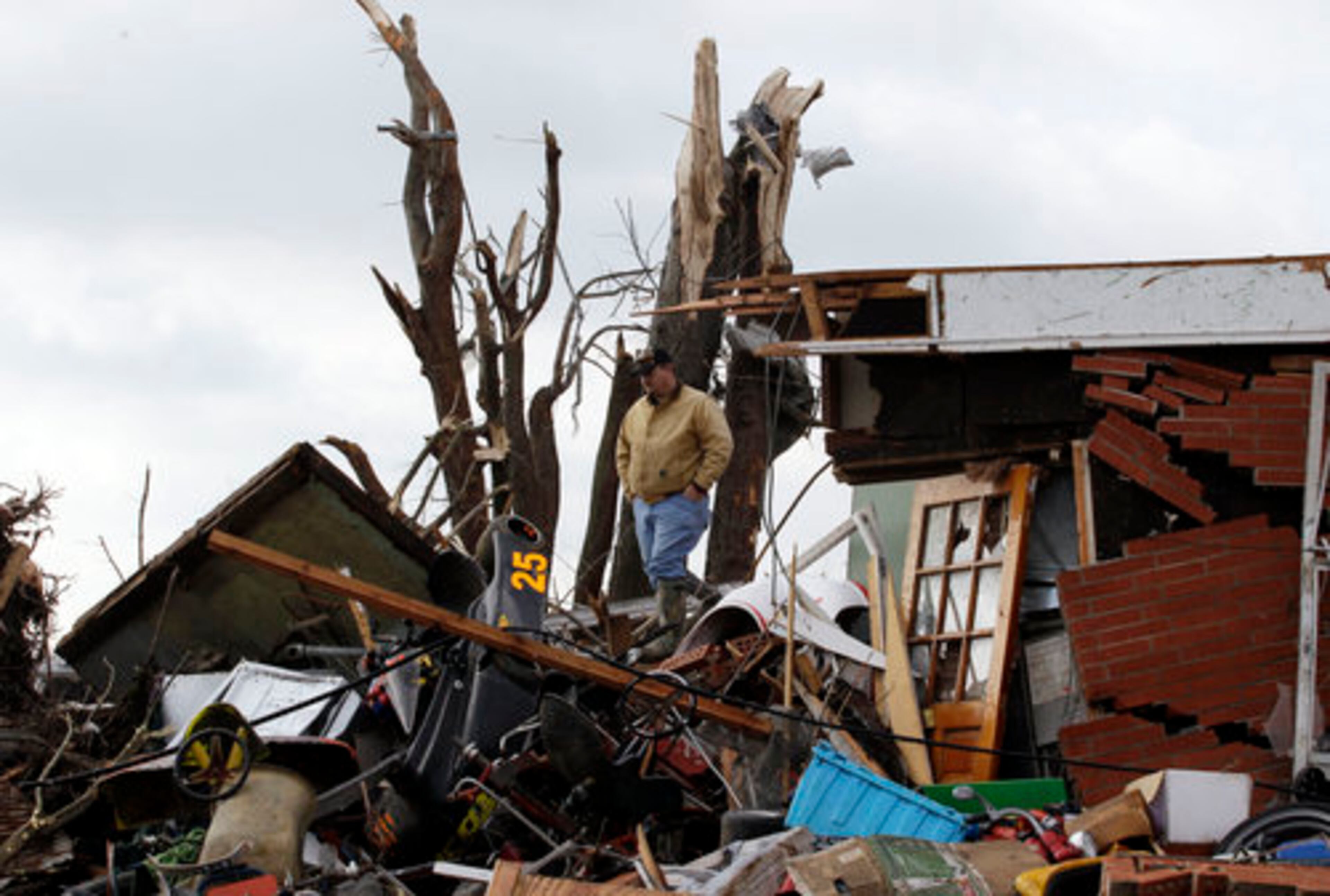 Kent Ater looks around a damaged house in Marysville, Ind., Saturday, March 3, 2012.