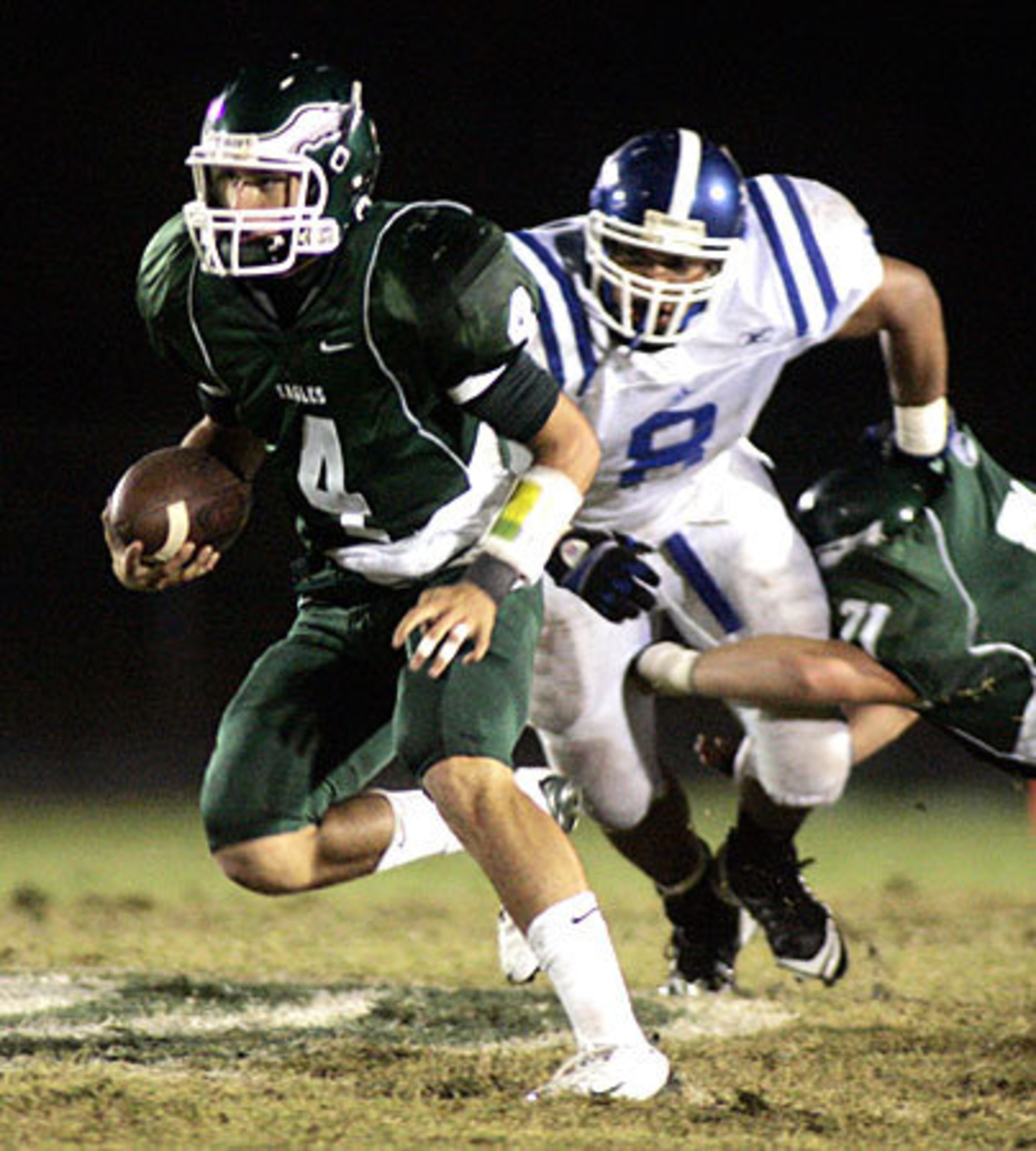 Collins Hill quarterback Michael Box (4) scrambles past Peachtree Ridge Michael Pate.