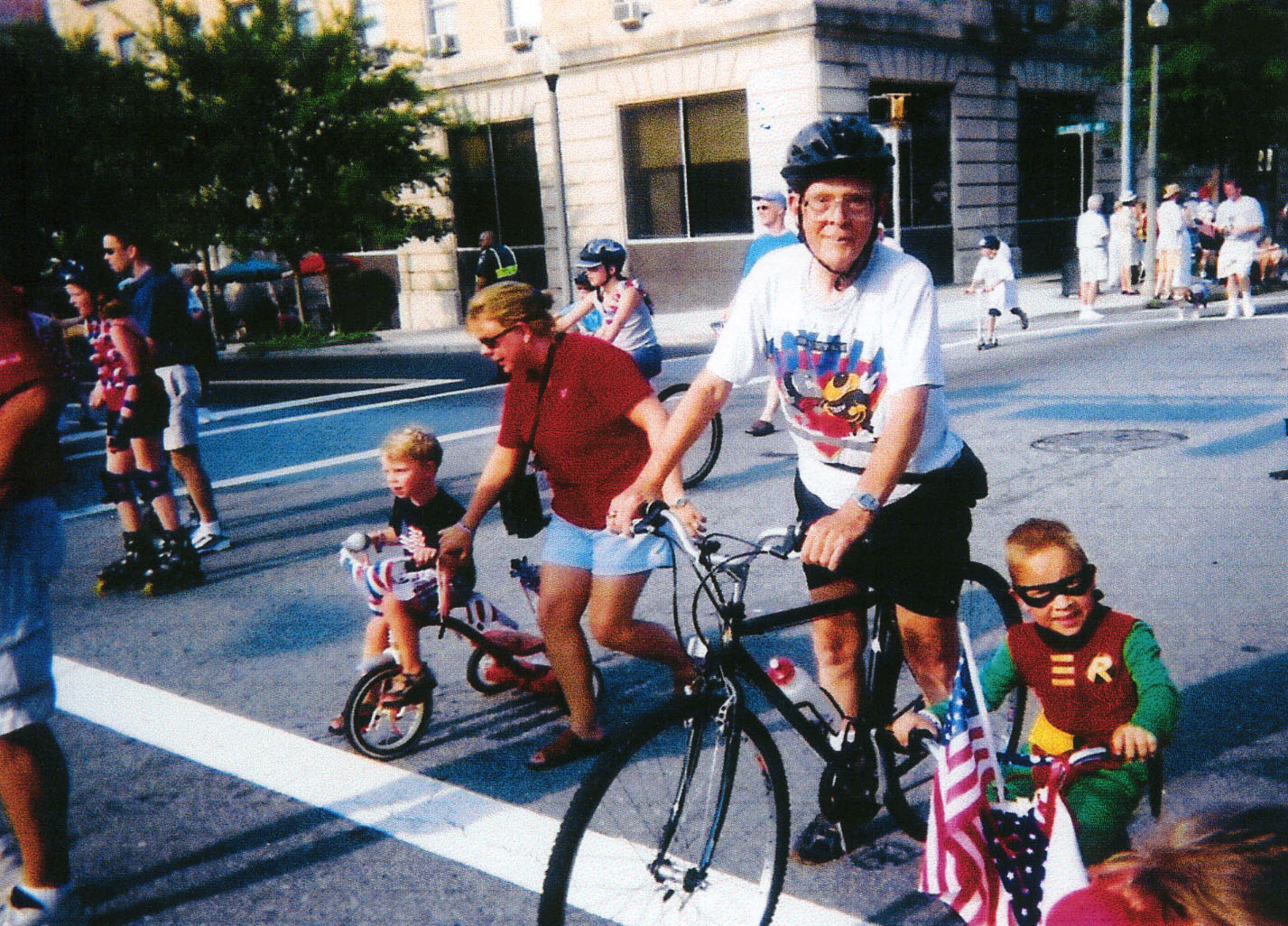 Ronald W. Gee riding his bicycle in a Fourth of July parade in Decatur
