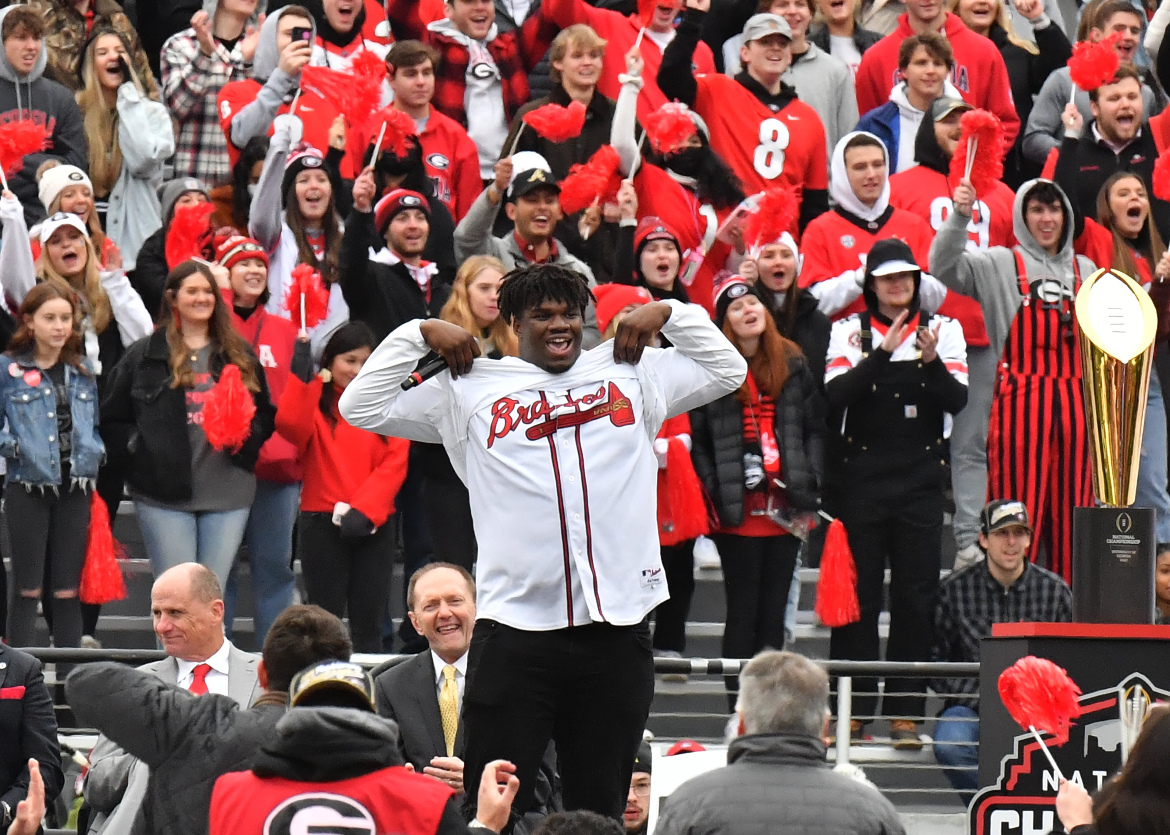 Georgia's defensive lineman Jordan Davis (99) shows his hidden Braves jersey under his shirt as he speaks on the stage during the celebration. (Hyosub Shin / Hyosub.Shin@ajc.com)