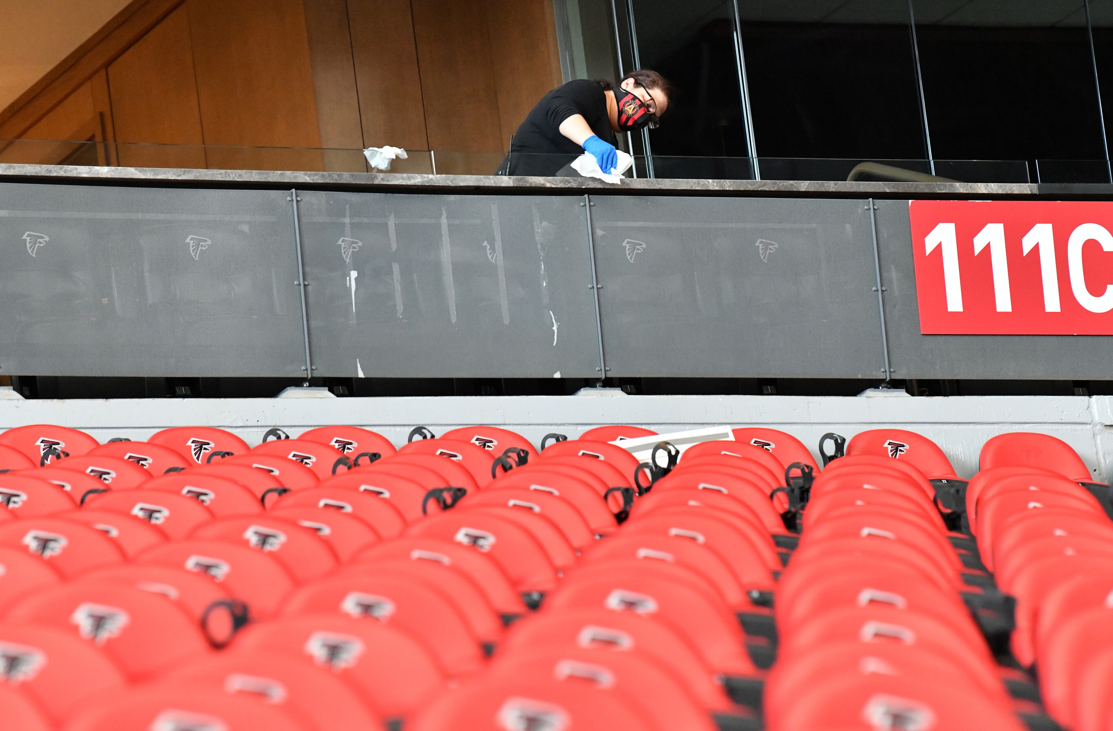 A cleaning crew wipes down glass dividers at Mercedes-Benz Stadium. (Hyosub Shin / Hyosub.Shin@ajc.com)