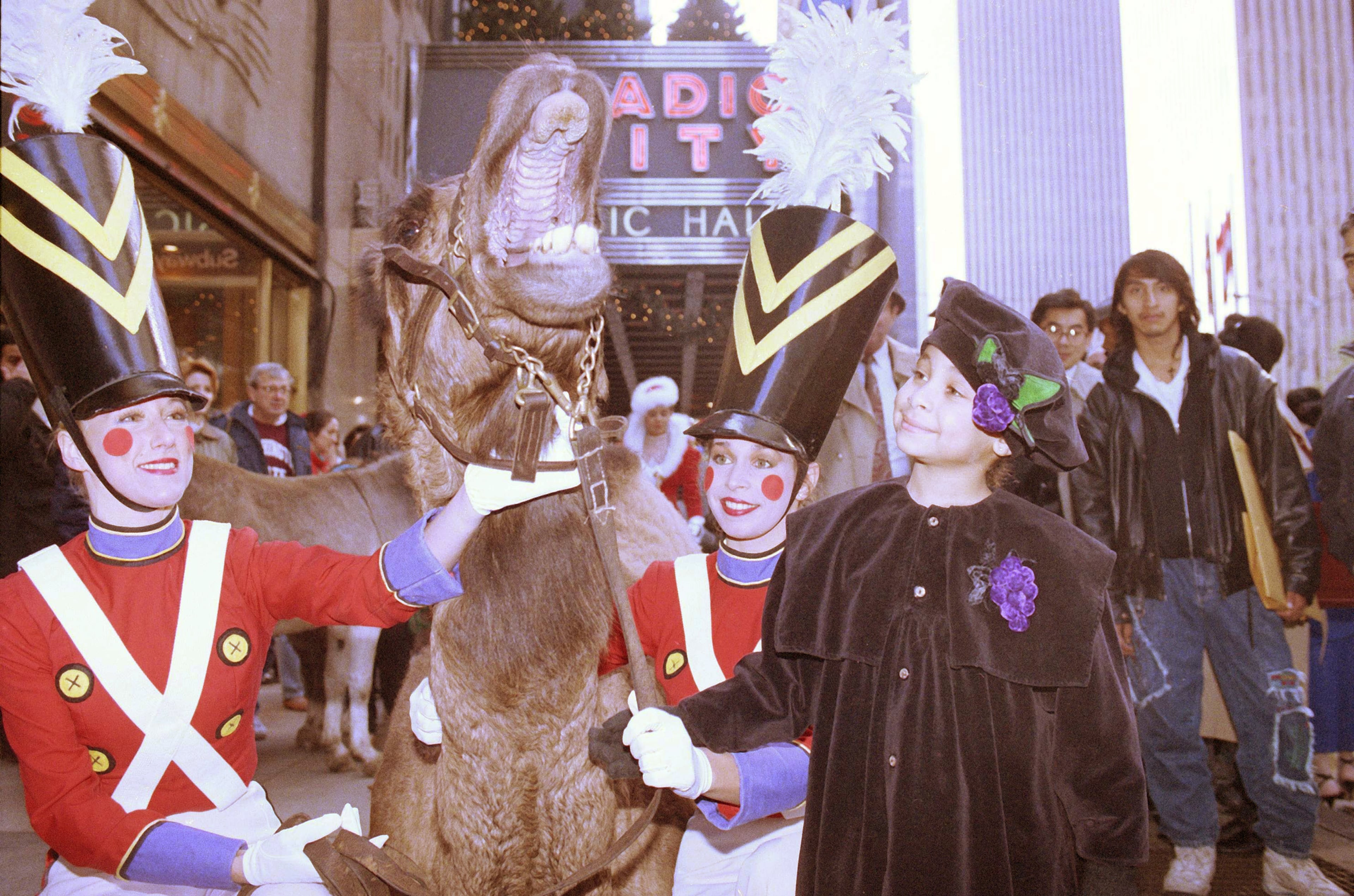 Raven-Symone of "The Cosby Show" is greeted by Azzuri the camel during the arrival of the four-legged co-stars of this year's "Radio City Christmas Spectacular" in New York on Nov. 13, 1991.