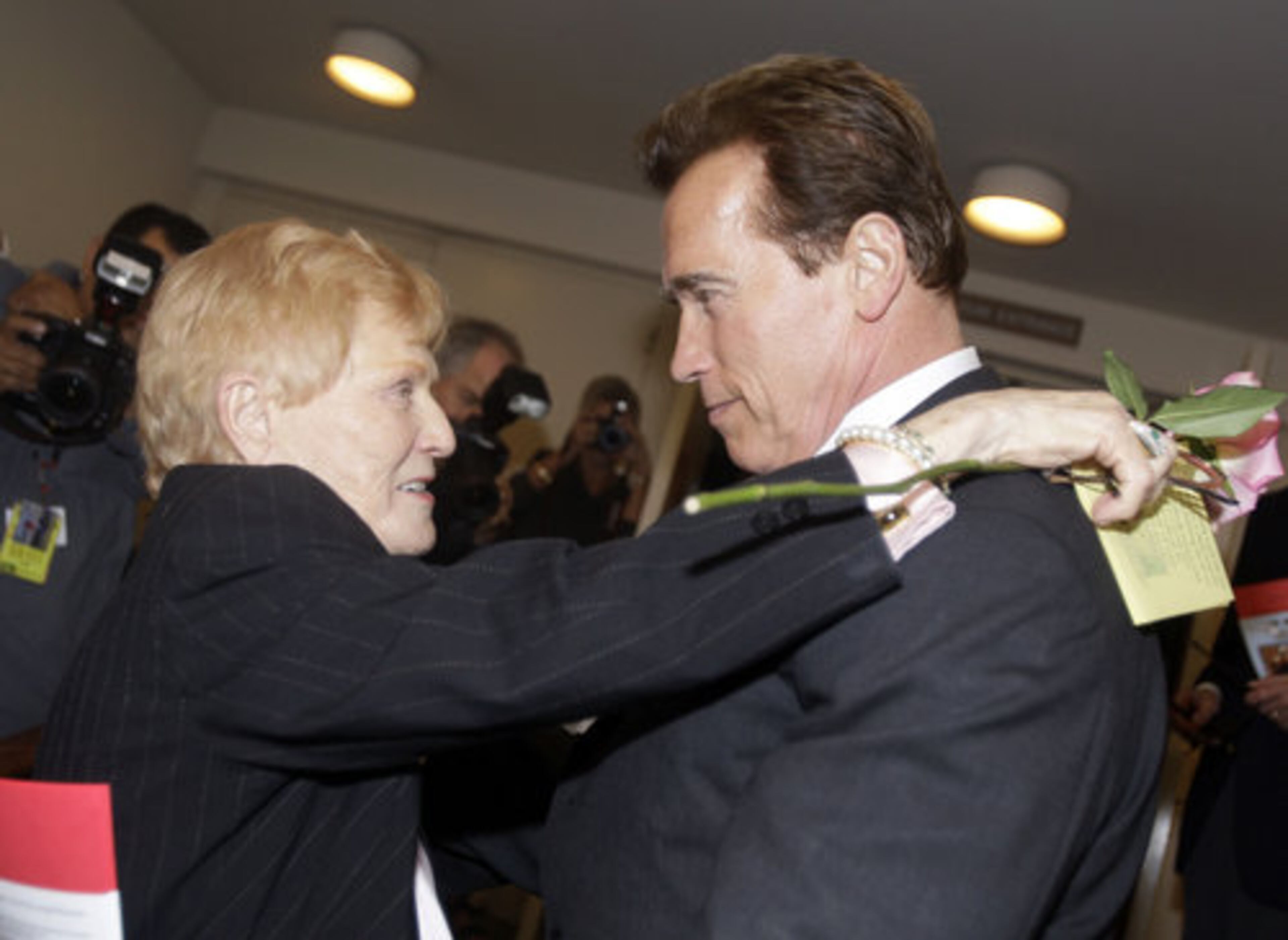Elaine LaLanne, widow of Jack LaLanne, left, embraces former California governor and body builder Arnold Schwarzenegger at a memorial service for her fitness guru husband.