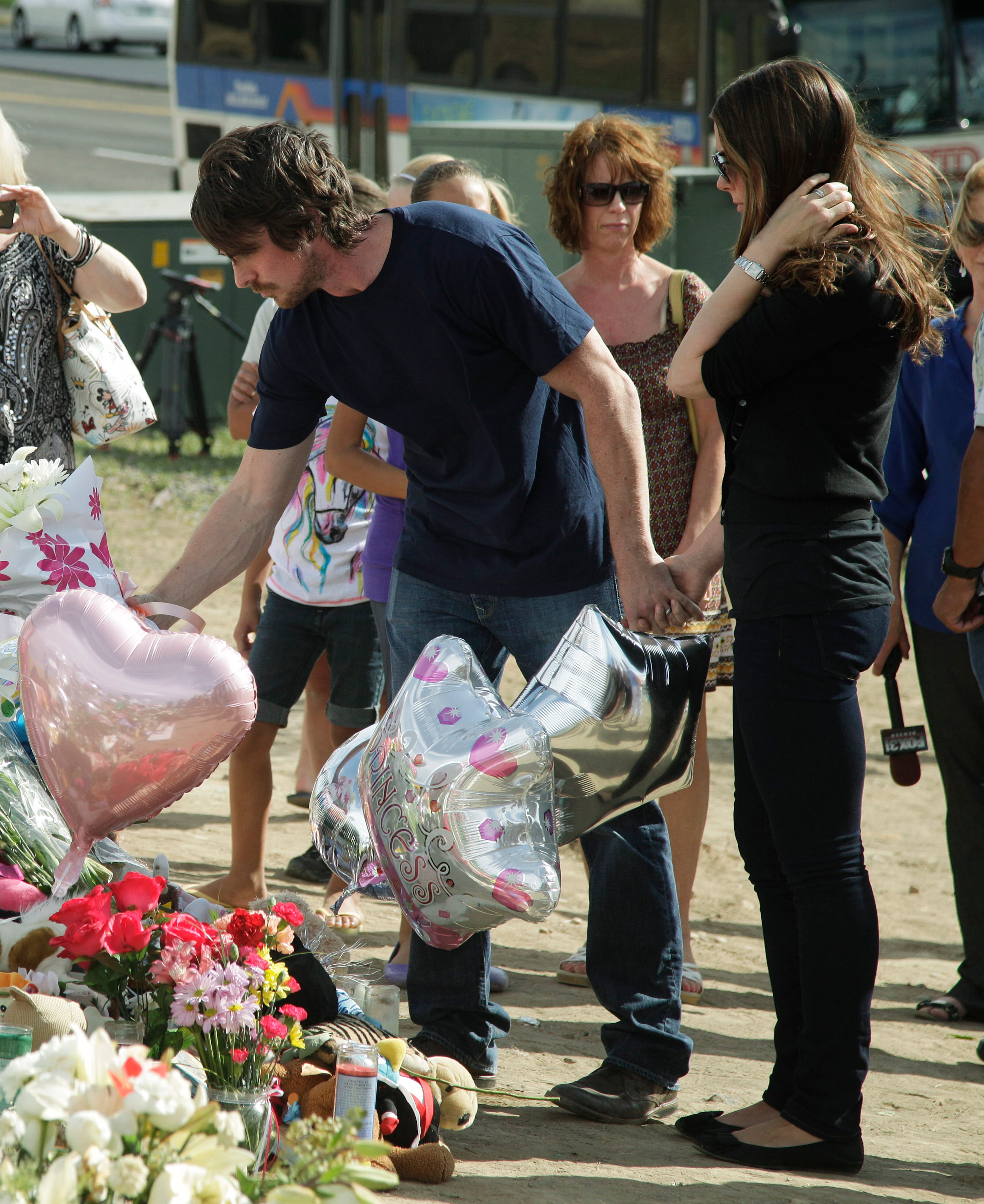 Actor Christian Bale and his wife Sibi Blazic visit a memorial to the victims of Friday's mass shooting, Tuesday, July 24, 2012, in Aurora, Colo. Twelve people were killed when a gunman opened fire during a late-night showing of the movie "The Dark Knight Rises," which stars Bale as Batman. (AP Photo/Ted S. Warren)