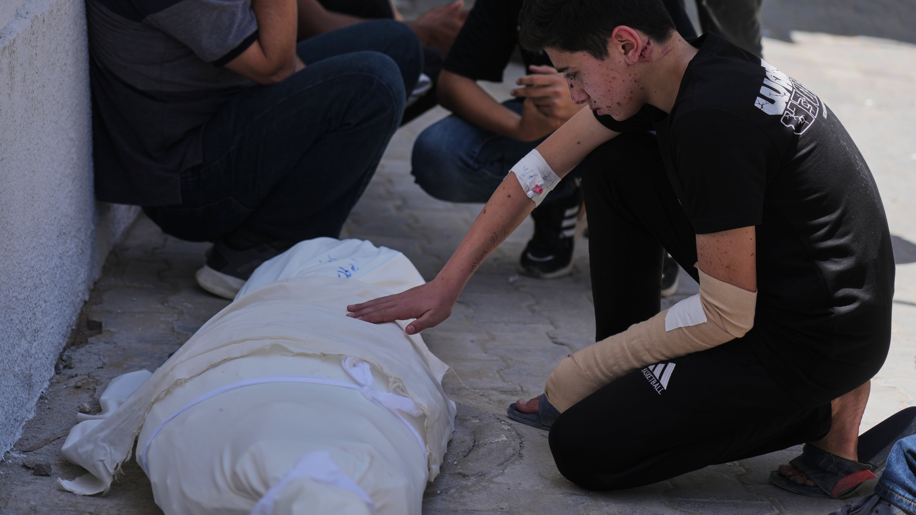 Omar Klaub, injured in an Israeli strike, mourns beside the body of his mother, Rana, who was killed in the same attack, during her funeral at Shifa Hospital in Gaza City, Thursday, June 4, 2026. (AP Photo/Jehad Alshrafi)