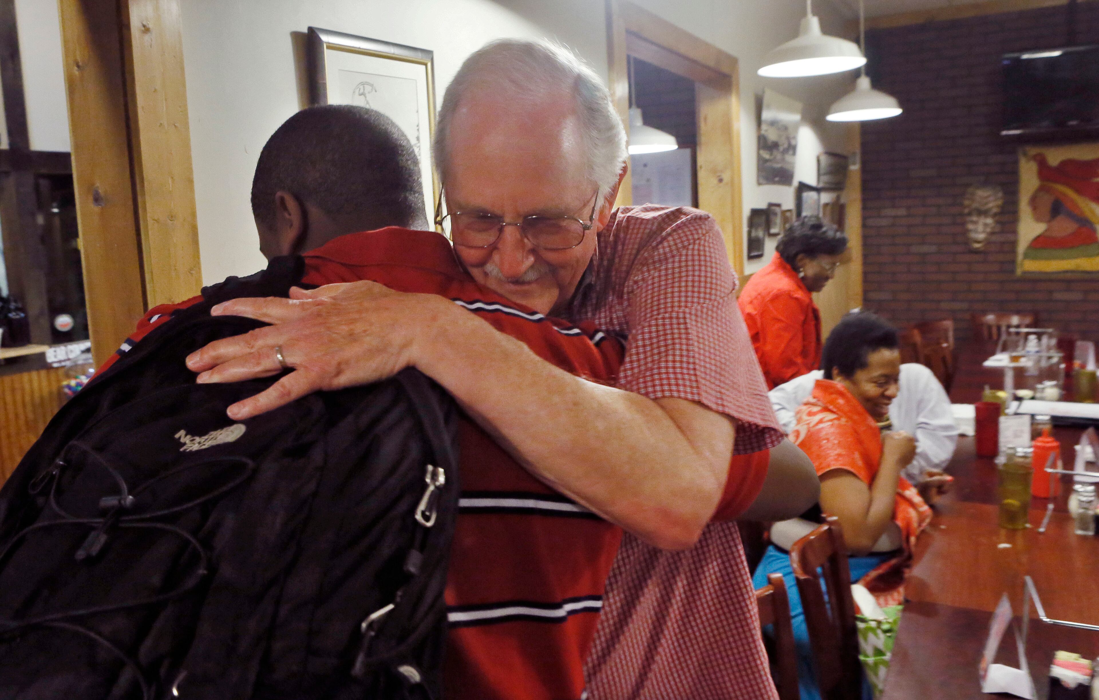 Art Collins gives Ashton Jordan a final hug for the night as he heads to grad night activities after celebrating with family members at Dagwood's Pizza in Norcross after Dunwoody High School graduation ceremonies. Since Ashton Jordan was 6 years old, Art Collins has been his mentor and had lunch with him every week. BOB ANDRES / BANDRES@AJC.COM