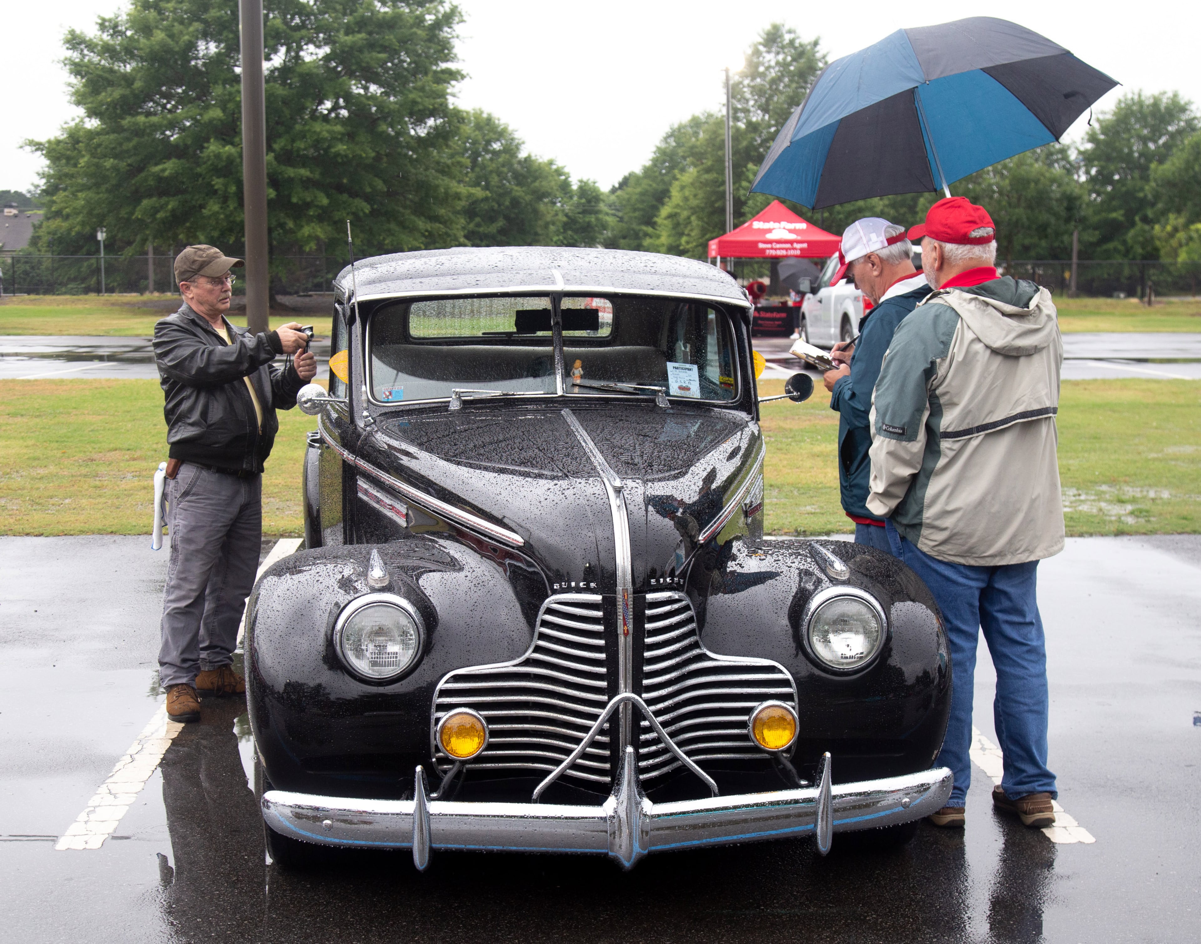 People look over a 1940 Buick during the Creepers Car Club’s 29th annual charity show in Marietta on Sunday, June 8, 2019. STEVE SCHAEFER / SPECIAL TO THE AJC