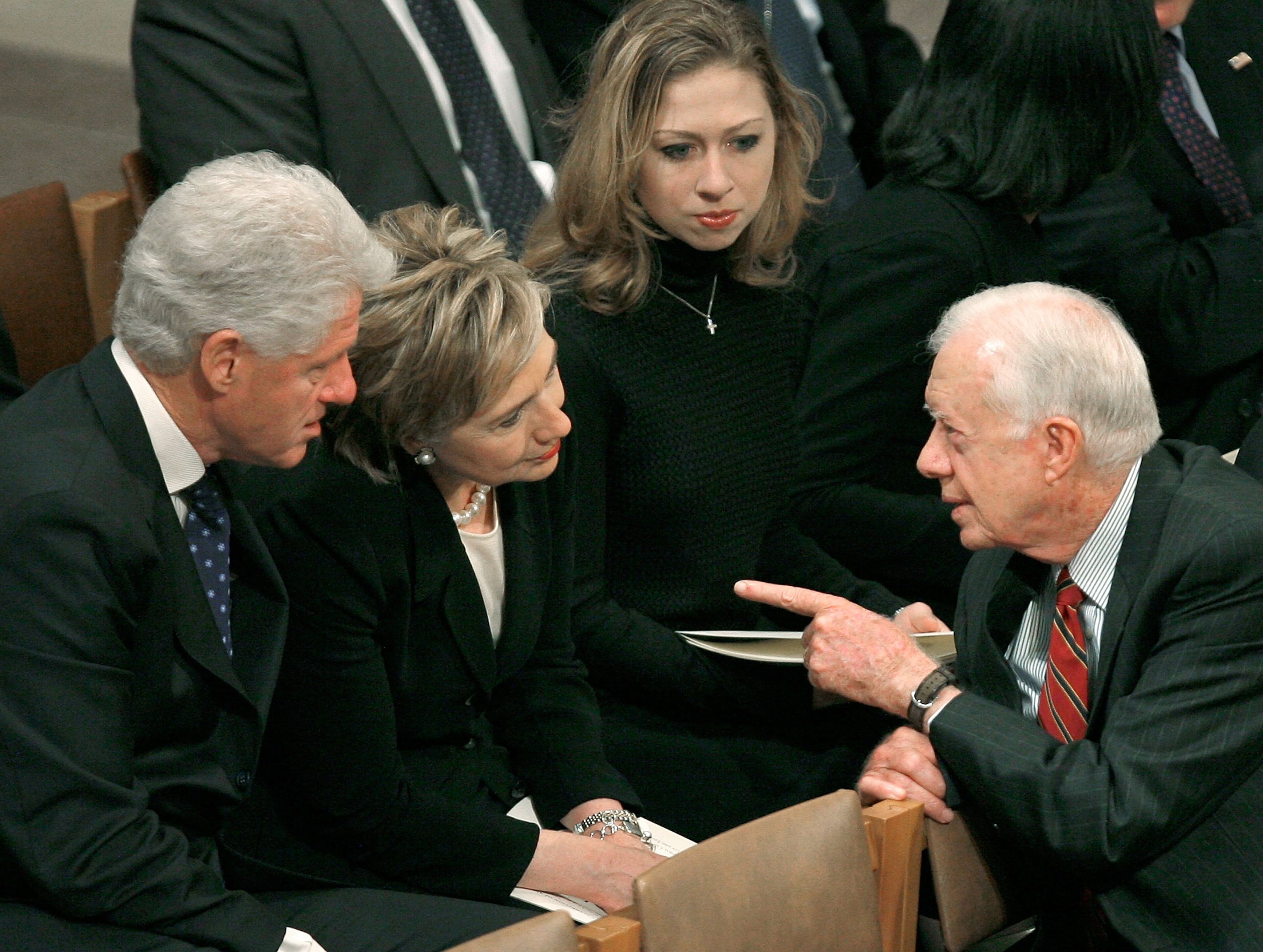 Former U.S. President Jimmy Carter (R) talks with former U.S. President Bill Clinton (L) and U.S. Sen. Hillary Clinton (D-NY) as Chelsea Clinton sits looks on during a funeral Service for former U.S. President Gerald Ford January 2, 2007 in Washigton DC. Ford who died on December 26, 2006 was honored during a funeral service at the Washington National Cathedral in Washington. (Photo by Mark Wilson/Getty Images)